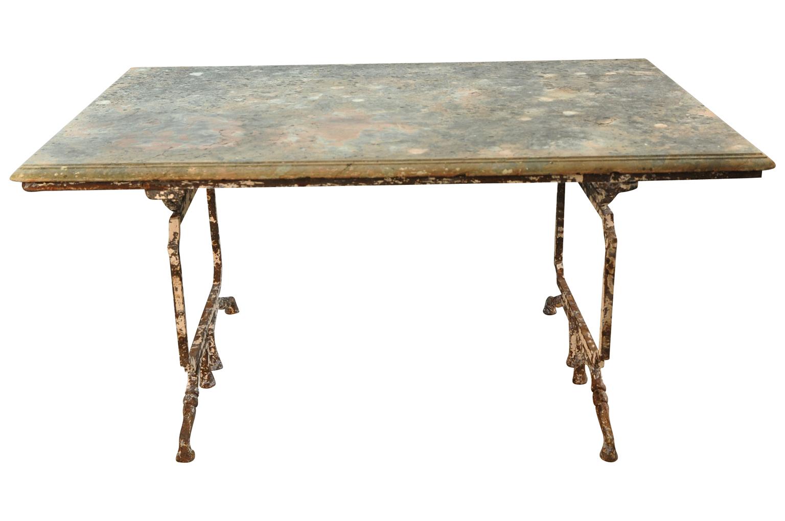 An outstanding later 19th century garden dining table from the Provence region of France. Beautifully constructed with a painted iron base and its original Rouge Royal marble top. Wonderful edge finish and sensational patina. Perfect for any