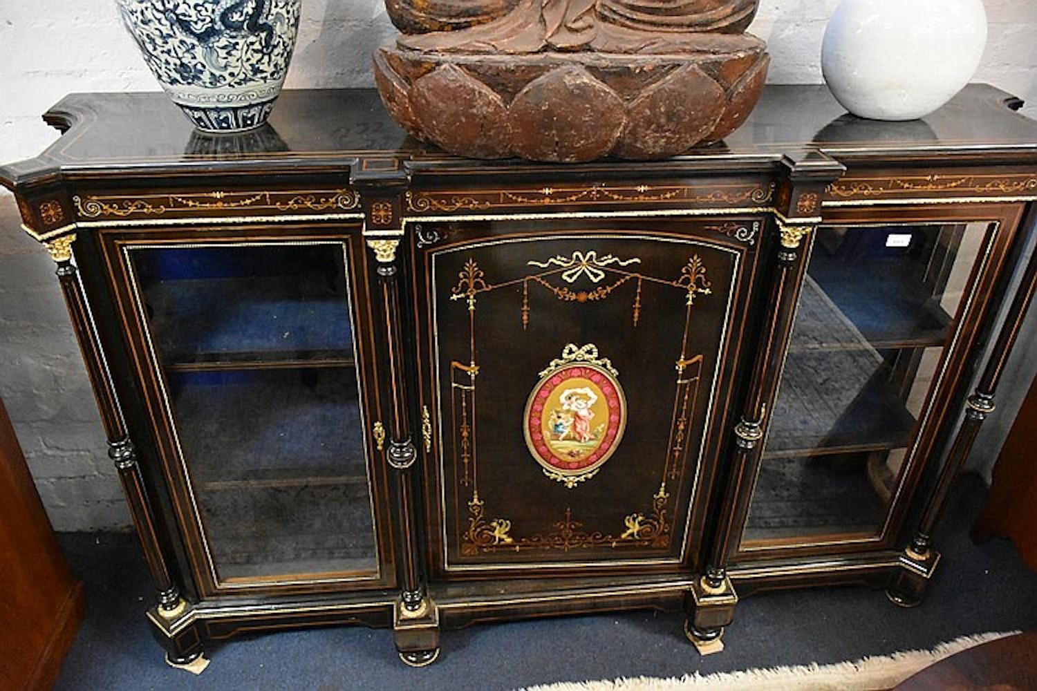 An outstanding French 19th century three-door ebon credenza having satinwood inlay and central hand painted Royal Vienna panel of the maiden. Measure: Height 113 cm, width 183 cm.