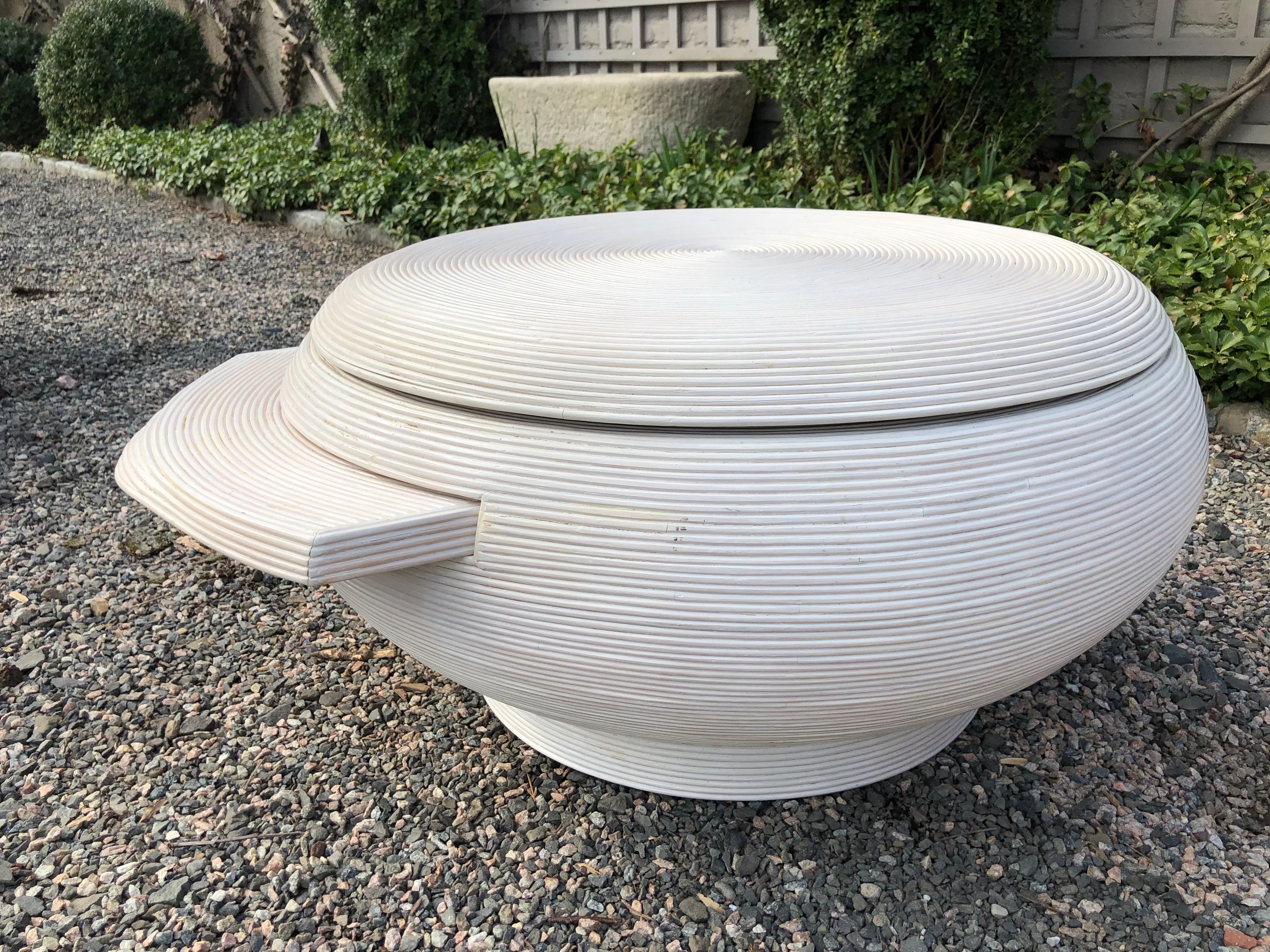Unique and chic whitewashed Mid-Century Modern rattan coffee table in the style of Gabriella Crespi having a swivel top and pullout or pull-out tray which remain invisible when not in use. Sculptural and sophisticated, the table has a modernist urn