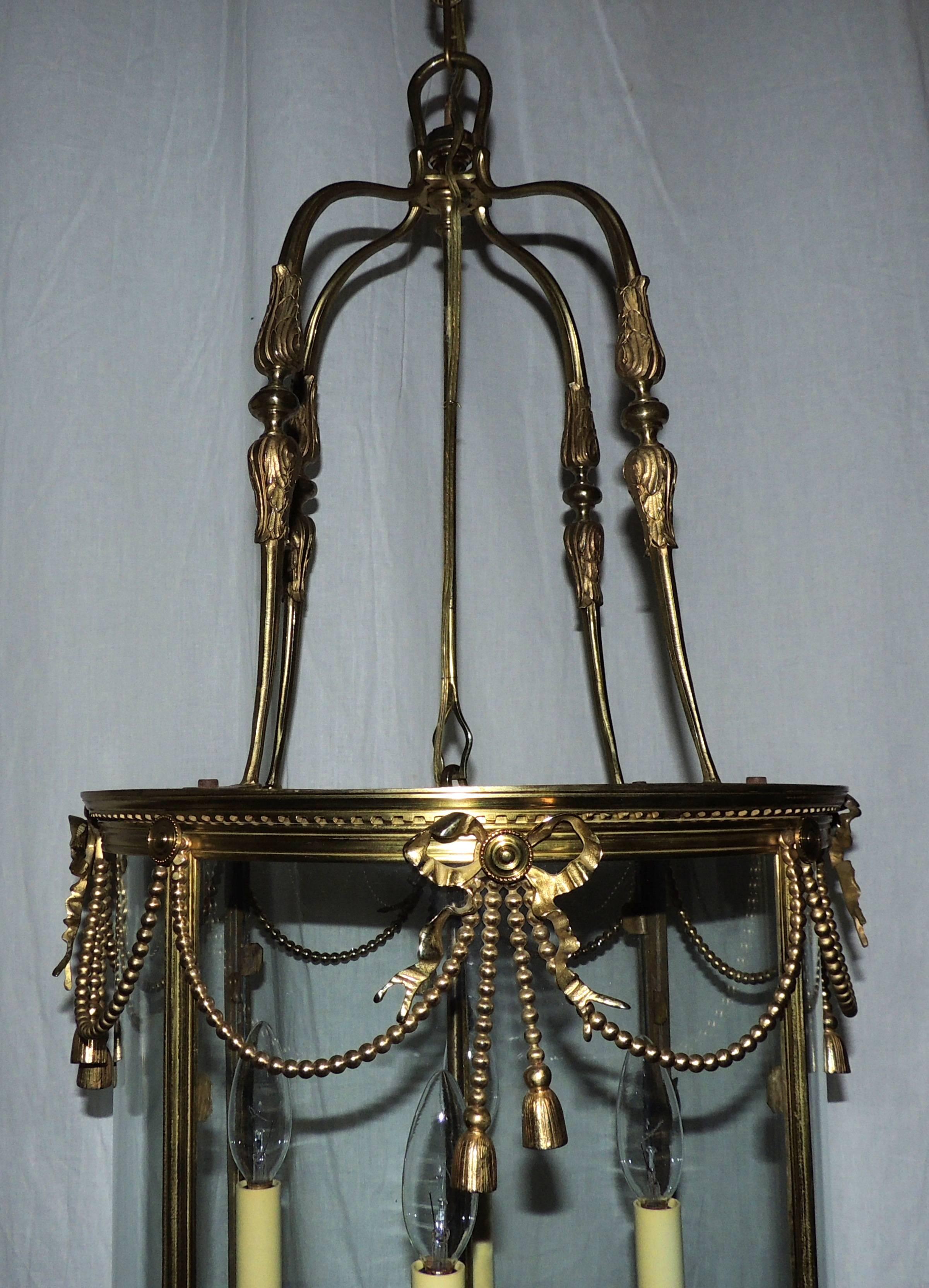 An outstanding French gilt bronze ribbon, bow lantern round bent glass panel chandelier fixture.