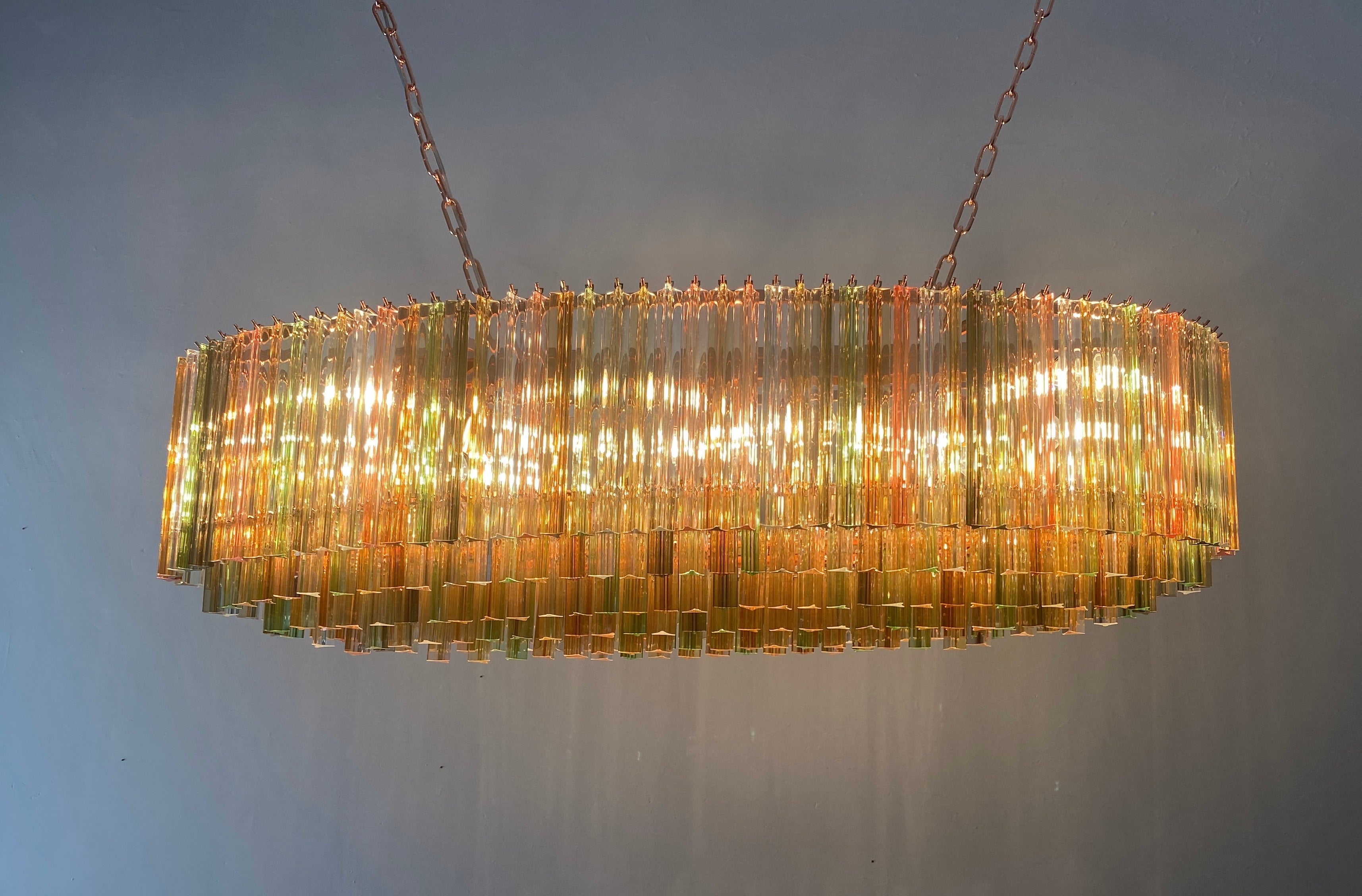 Magnifique lustre de Murano fait de prisme triedi multicolore en cristal de Murano sur six niveaux avec une armature en métal de couleur cuivre.
Les verres sont ambrés, transparents, fumés, ambrés, dorés,  rose, transparent  et vert, créant un