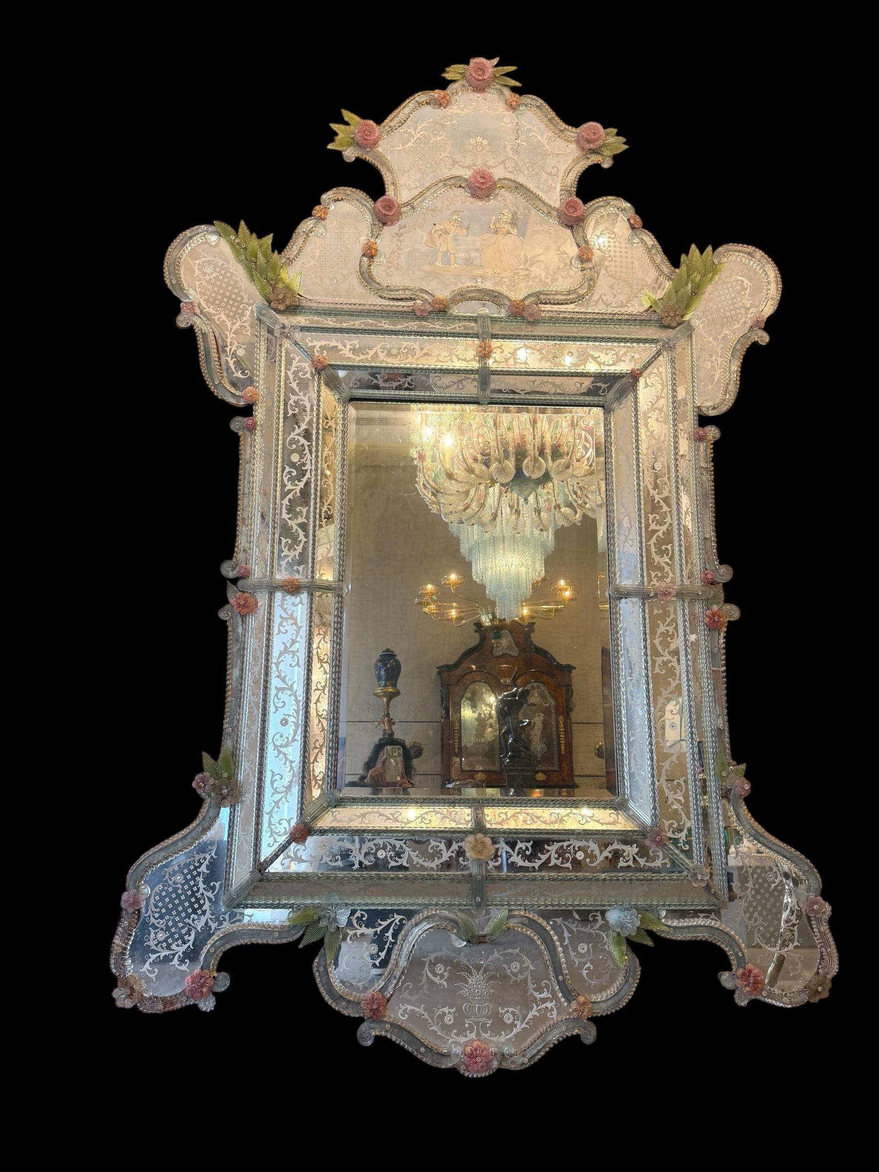 Este hermoso espejo veneciano presenta motivos florales grabados que adornan el marco espejado. A lo largo de los bordes del marco hay detalles de cuerda de cristal y numerosas flores rosas y verdes de cristal.
Ejecutado por el gran Maestro de