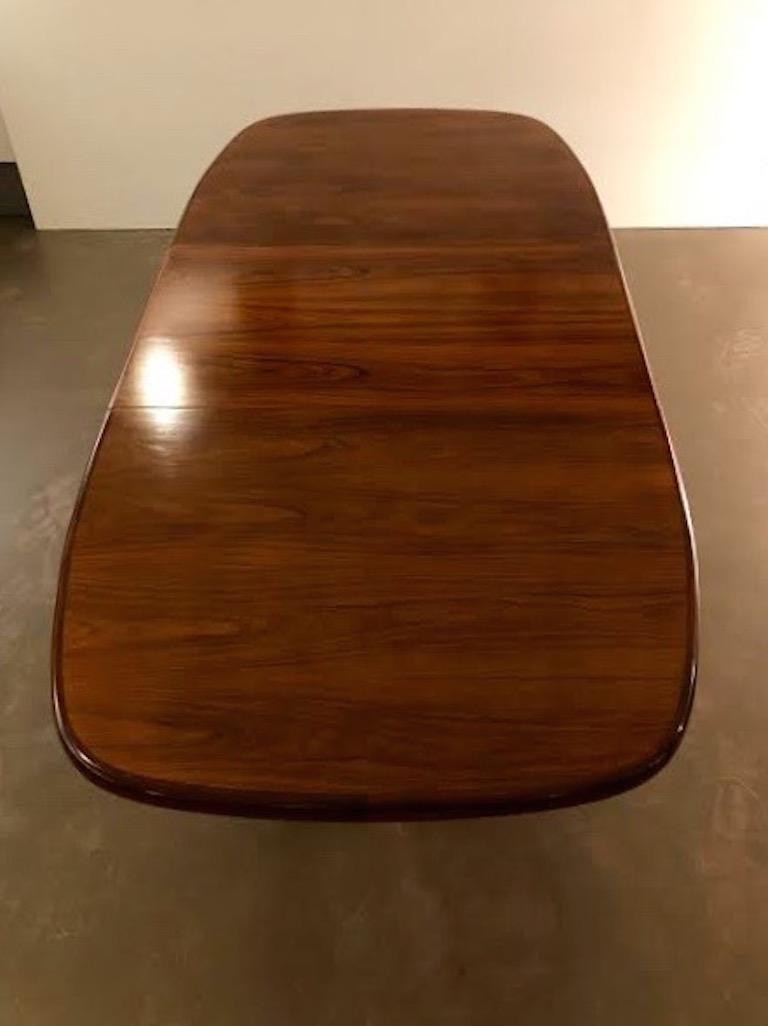 A functional Danish rosewood Mid-Century Modern Scandinavian Modern dining table designed by Randers Møbelfabrik,. The table has a beautiful rosewood grain, stately cross base with two leaves. It is structurally sound and in good condition.
Very