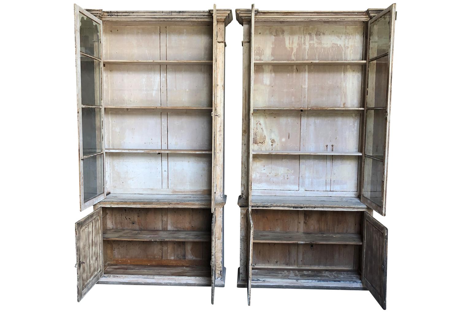 An outstanding pair of 19th century bookcases from the South of France. Beautifully constructed from painted and scraped wood. Wonderful glass and patina. The width at the crown measures 59 1/8