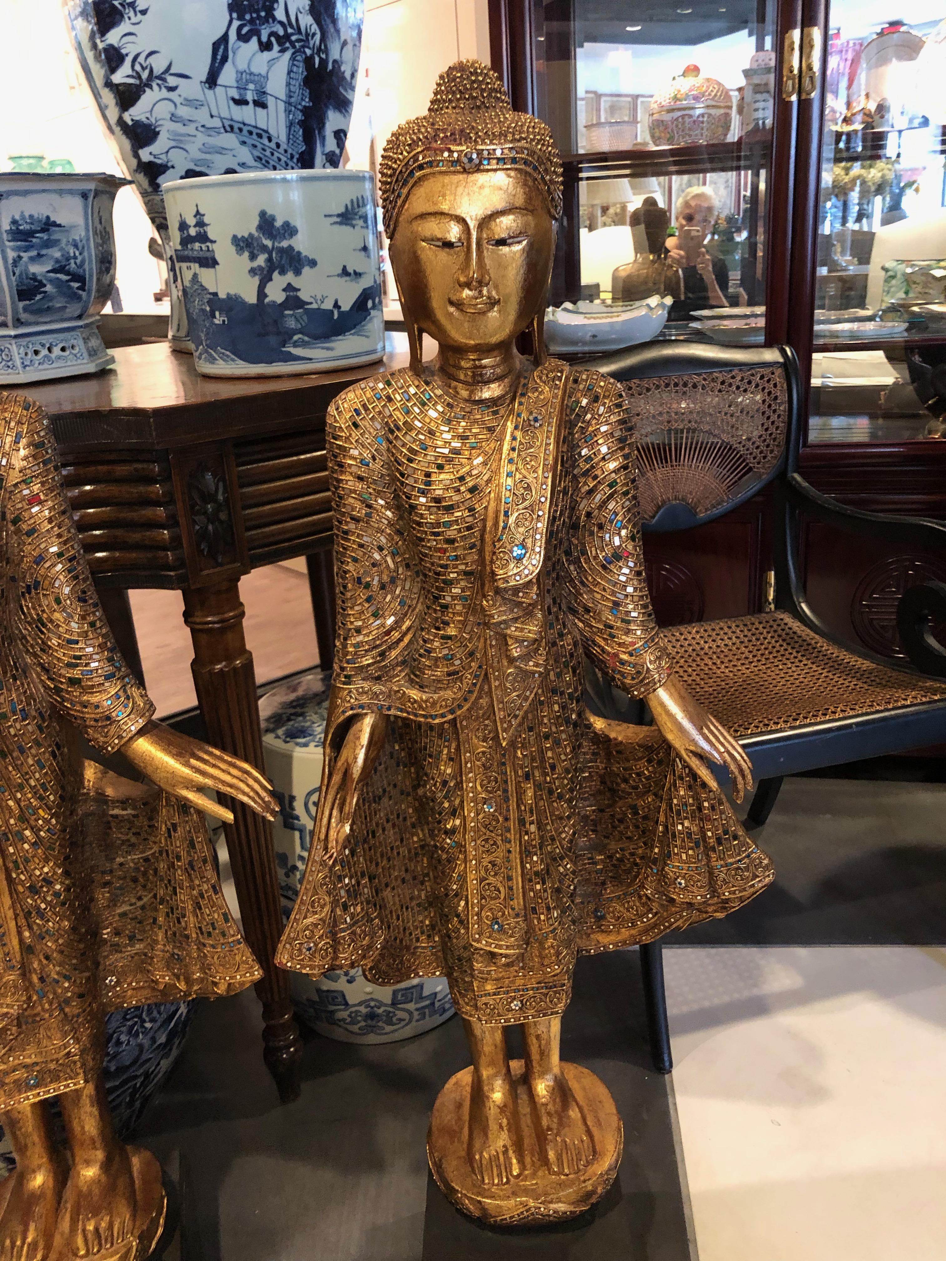 Handcrafted and gold leafed with cut multi-colored mirror rectangle pieces put into the gold robes Looking at the faces one looks more female and one looks more male. These Gandhara Buddhas are Standard gesture of greeting in the 