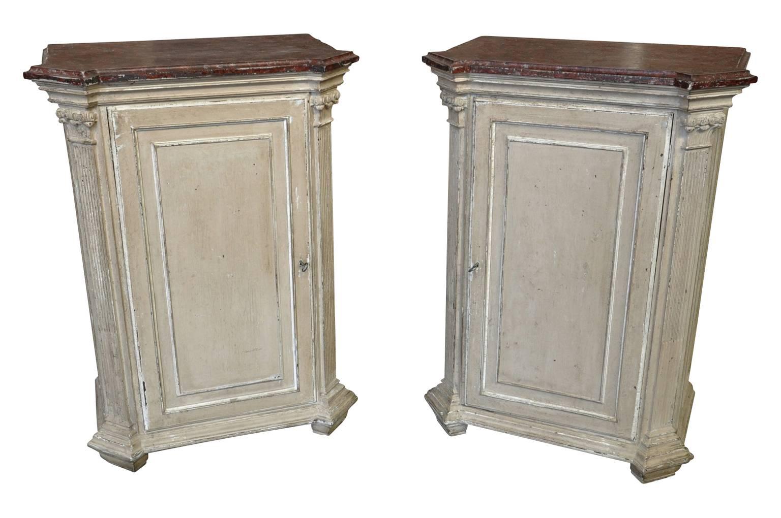 A fabulous pair of French Louis XVI style side cabinets from the Provence region. Beautifully constructed from painted wood with outstanding faux marble painted top surfaces.