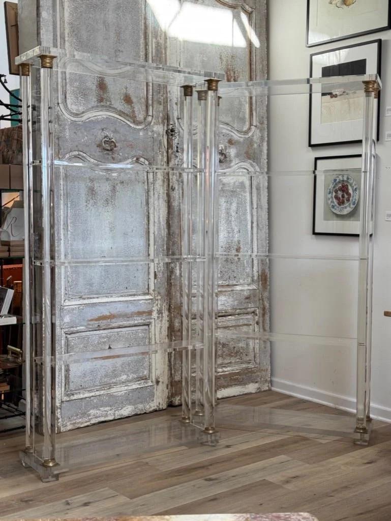 Exceptionnelle paire d'étagères en acrylique ou en lucite de la Maison Maison Jansen, milieu du siècle dernier.  Tous deux ont des plateaux rectangulaires sur quatre colonnes doriques supportant trois étagères, chaque colonne ayant des chapiteaux