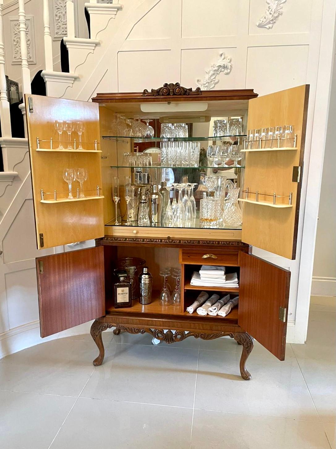 

Outstanding quality antique burr walnut cocktail cabinet. The top section boasts a polished top and a carved walnut pediment above a pair of quality burr walnut doors with delightful original engraved brass hinges and original engraved brass