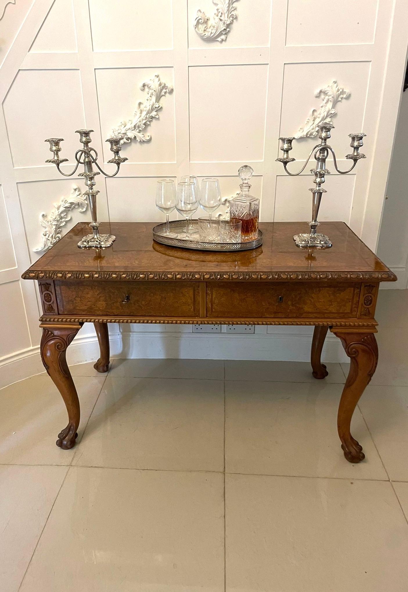 Un tavolo da salotto/console indipendente in radica di noce di qualità eccezionale con un favoloso piano in radica di noce di forma rettangolare con bordo intagliato sopra due cassetti in radica di quercia fiancheggiati da campane e fiori in noce