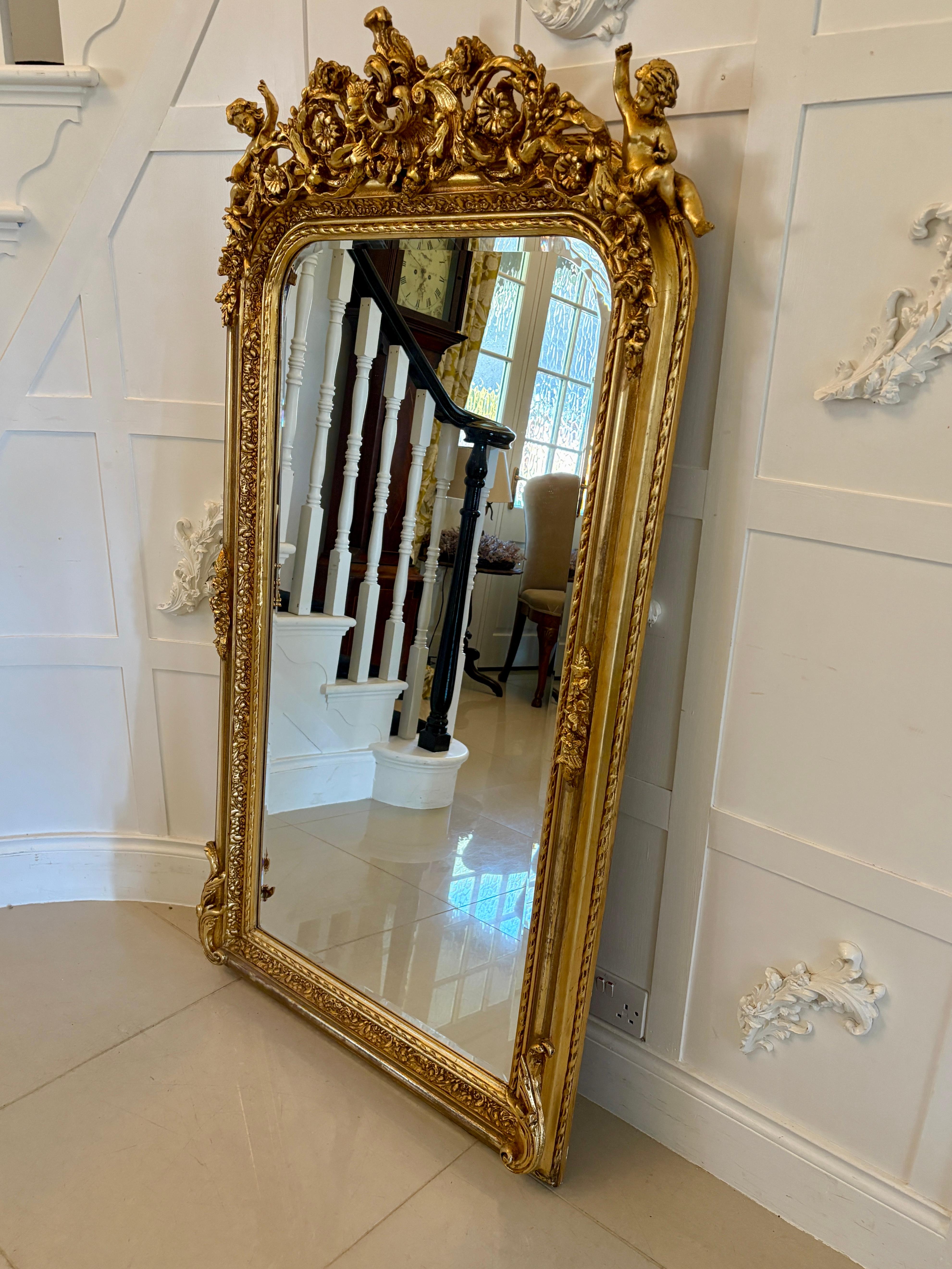 Miroir mural de qualité exceptionnelle avec cadre doré sculpté de l'époque édouardienne. Le bord biseauté d'origine est entouré d'un magnifique cadre doré.  cadre sculpté et doré avec des chérubins et un décor de rinceaux.

Un exemple exceptionnel