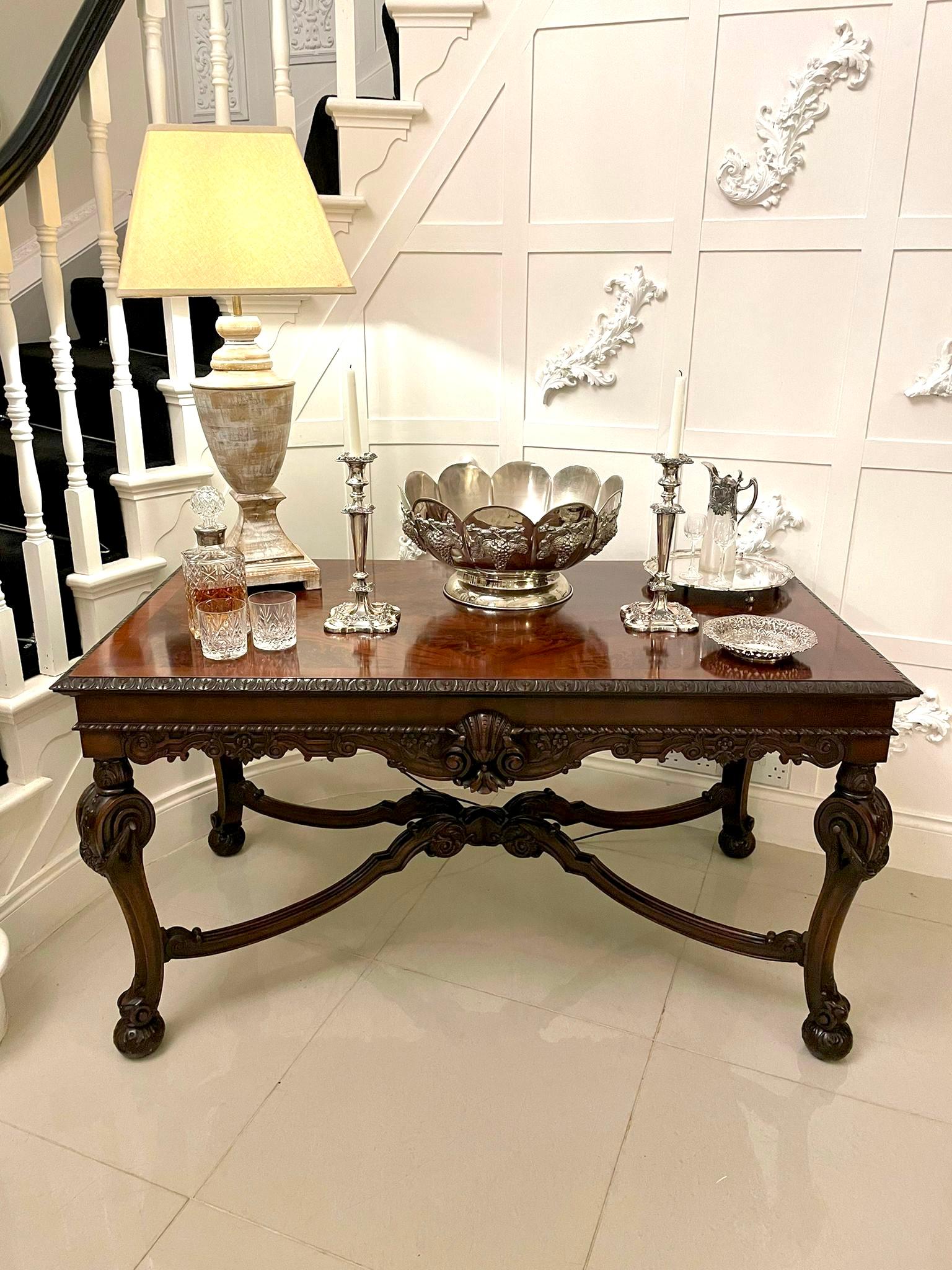 Outstanding quality antique Edwardian freestanding carved mahogany centre table having a fantastic quality figured mahogany crossbanded top with a quality carved edge above a carved mahogany shaped frieze with shells and scrolls. It stands on four