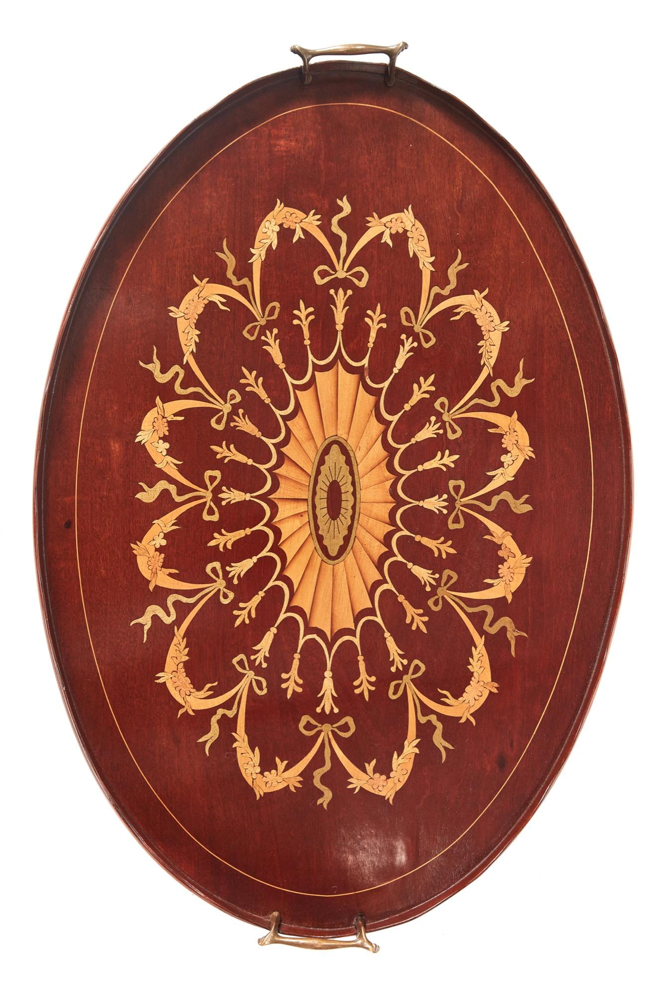 Outstanding quality Edwardian inlaid mahogany oval tray with original brass handles. It has a striking intricate inlaid centre with garlands around a large shell.


 