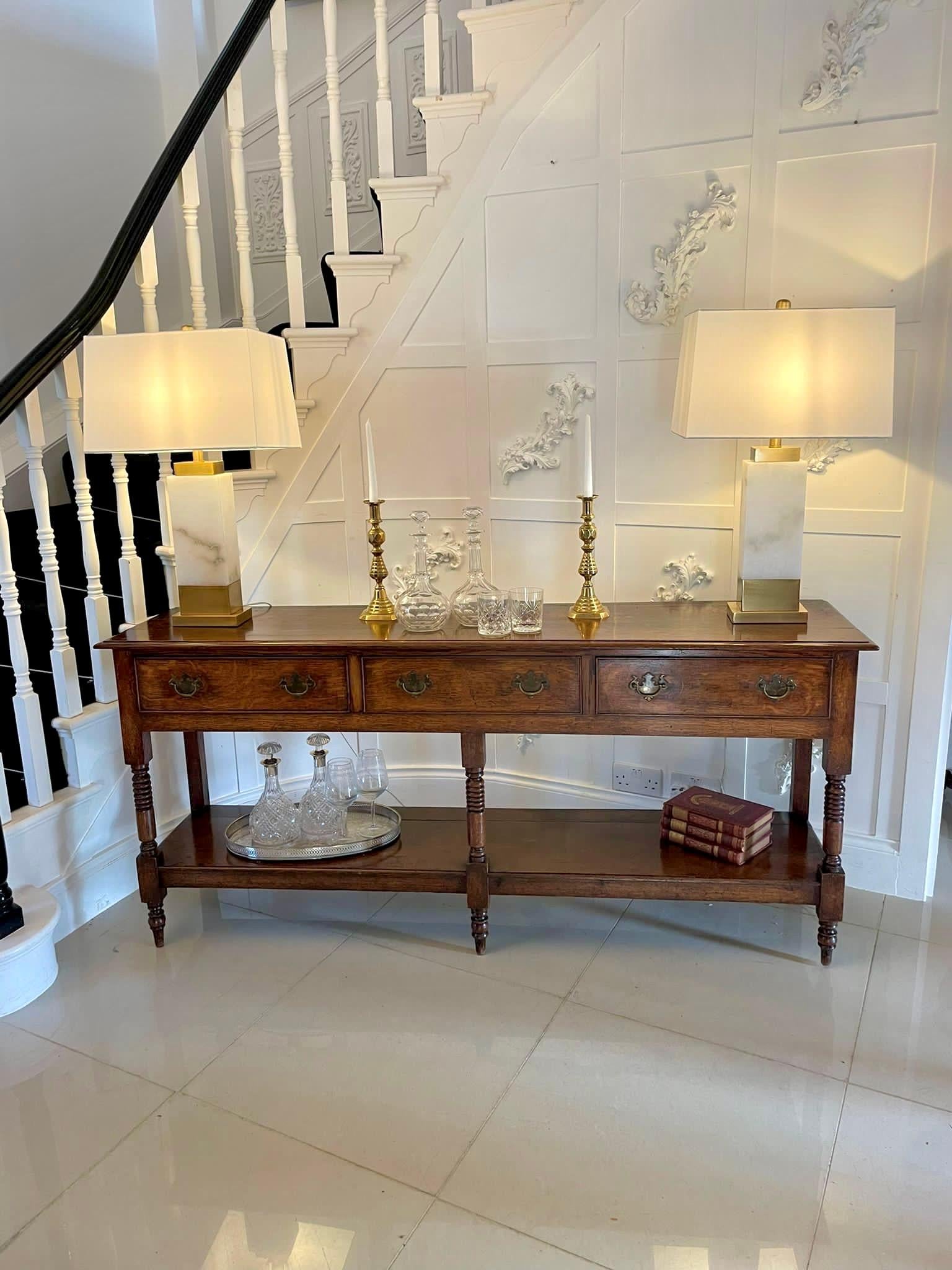 Outstanding quality antique George III oak dresser base having a quality oak rectangular shaped top with a moulded edge above 3 long cockbeeded drawers with brass handles, turned oak supports standing on elegant turned feet united by an oak pot