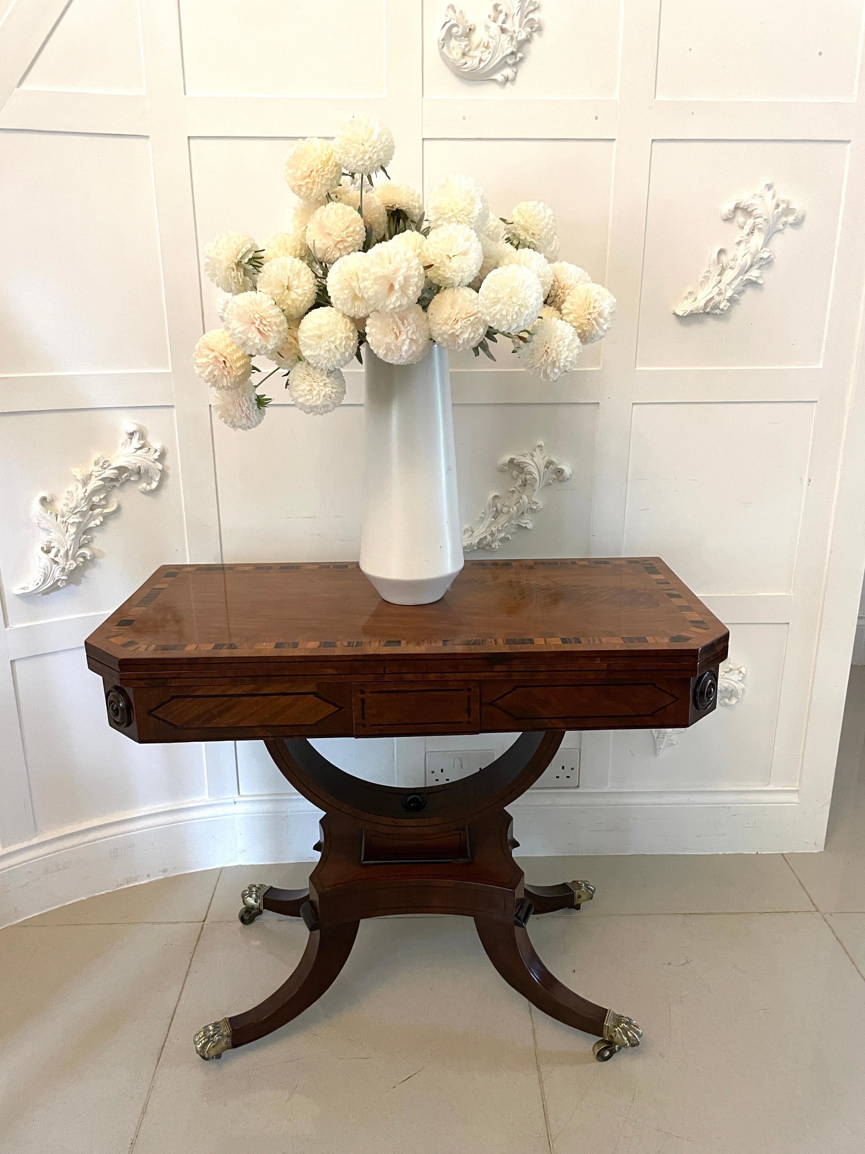 Excepcional mesa de cartas/consola de caoba antigua de la época de la regencia, con tablero de caoba de excelente calidad, con bandas cruzadas de madera de coromandel, que se abre para revelar el interior original de batista, friso de caoba con