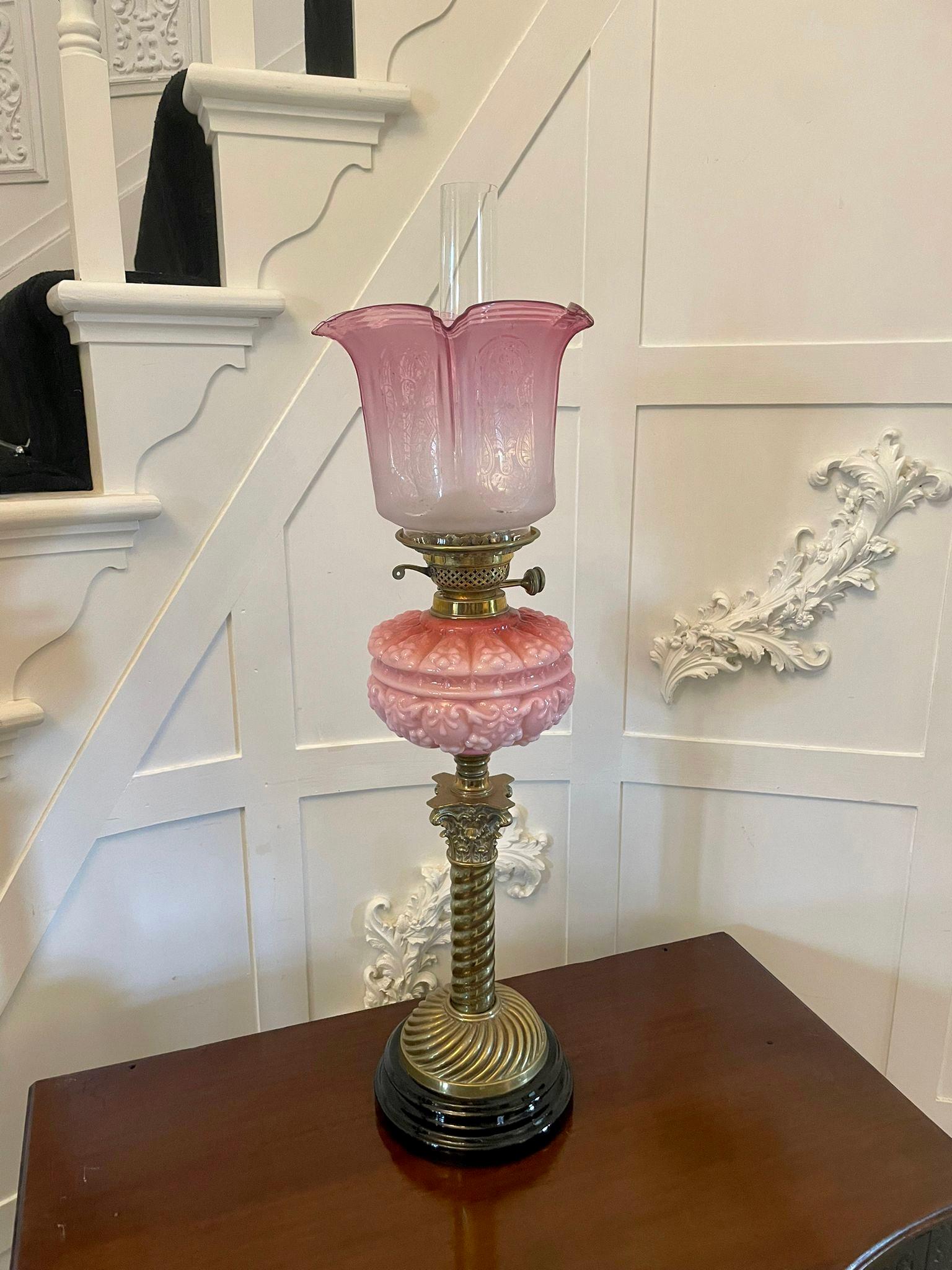 Outstanding quality antique Victorian brass and pink glass oil lamp having the original cranberry glass shade and chimney outstanding quality pink glass font with double burners supported by a rope twist column standing on a circular base


A
