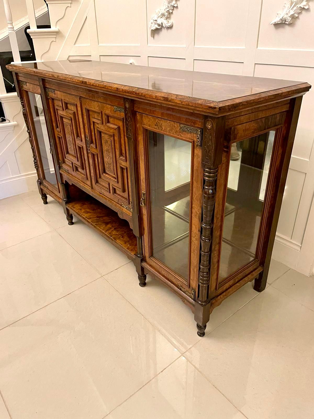 Outstanding quality antique Victorian burr walnut credenza having an outstanding quality burr walnut top with moulded edge. It boasts a stunning pair of walnut moulded panelled and carved doors to the centre with original ornate brass hinges, the