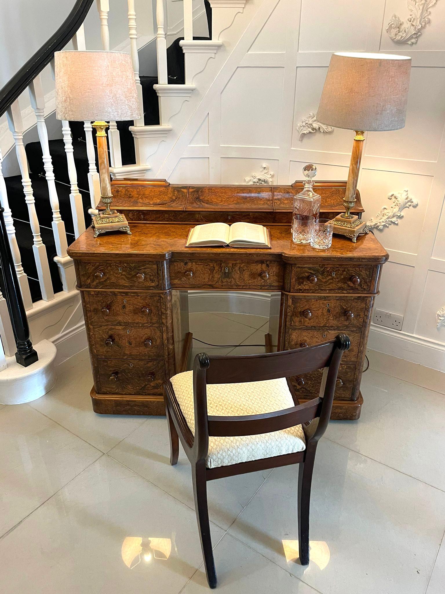 Outstanding quality antique Victorian burr walnut kneehole desk by Maple & Co. having a magnificent quality burr walnut top with three serpentine shaped lift up lids opening to reveal storage compartments above a kneehole desk with nine burr walnut