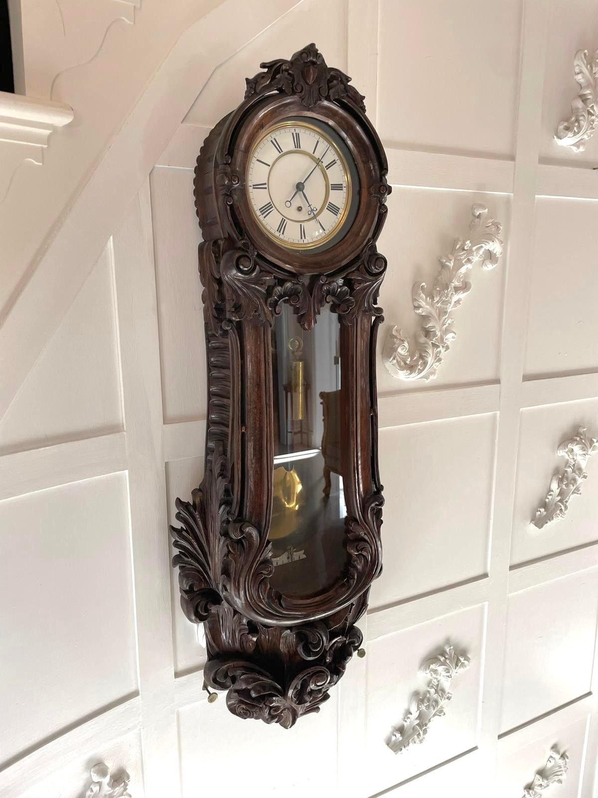 Outstanding quality antique Victorian carved oak Vienna wall clock boasting a fabulous quality carved oak case carved with scrolls, leaves and flowers, single glazed door opening to reveal a circular porcelain dial with original hands, 8 day