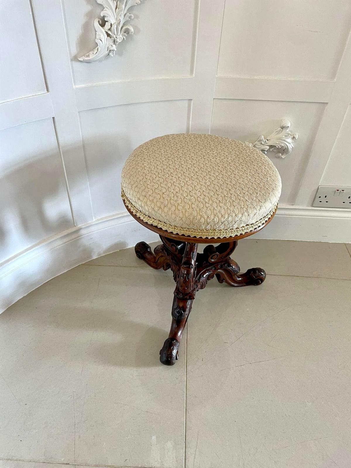 Outstanding quality antique Victorian carved walnut stool having a newly reupholstered circular shaped seat in a quality fabric above an outstanding quality carved solid walnut basket shaped base. It is raised on three lovely shaped carved solid