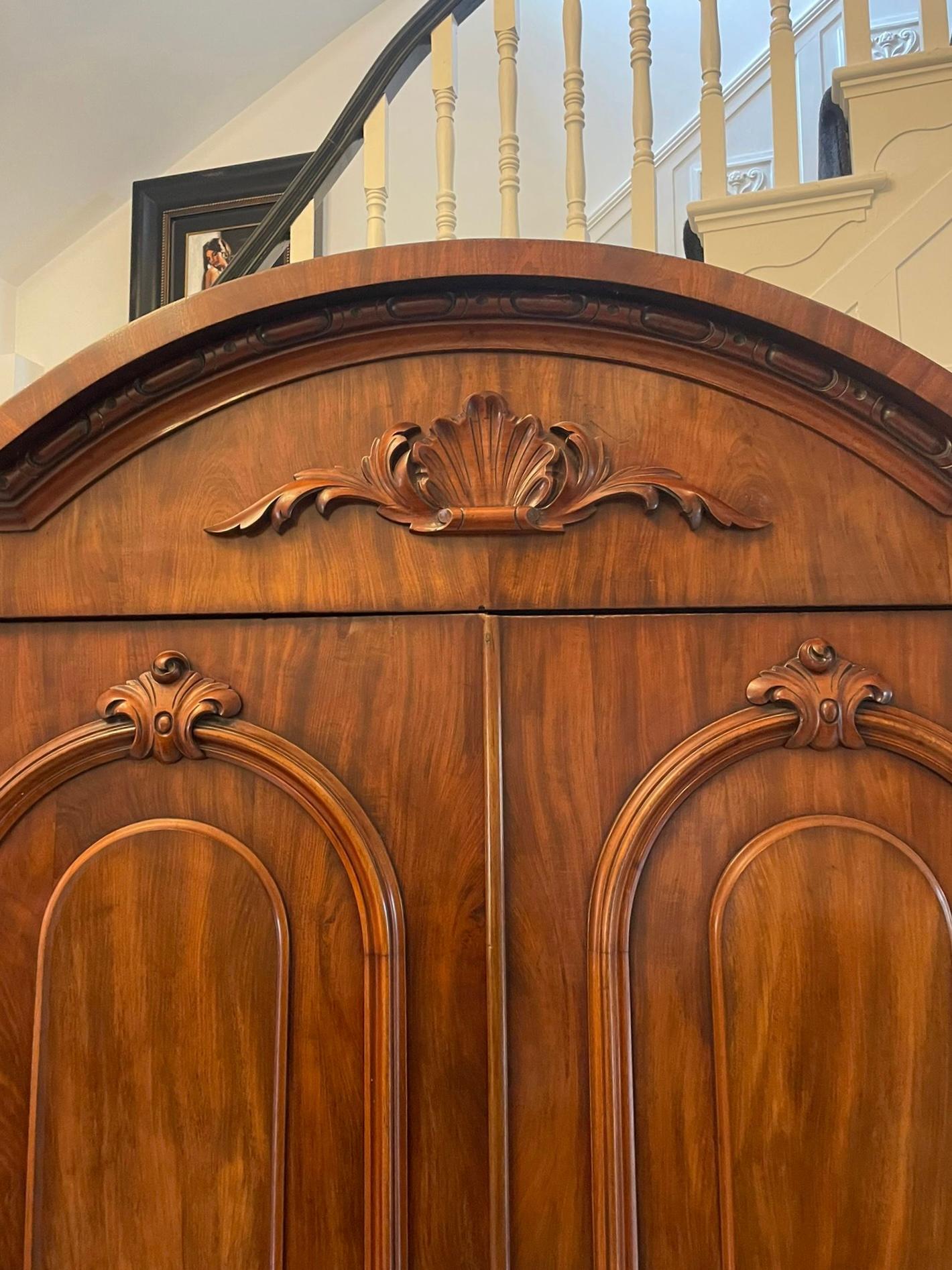 Outstanding quality antique Victorian figured mahogany wardrobe having an fabulous quality figured and carved mahogany arched top cornice above a pair of figured and carved mahogany 
moulded panelled doors opening to reveal two hanging compartments