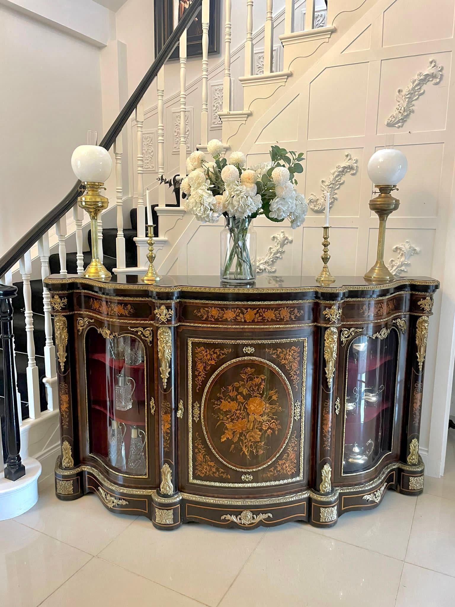 Outstanding quality antique Victorian floral marquetry ormolu mounted serpentine shaped credenza having a serpentine shaped ebonised top with an ornate ormolu edge above a floral marquetry ormolu mounted serpentine shaped frieze. It boasts a