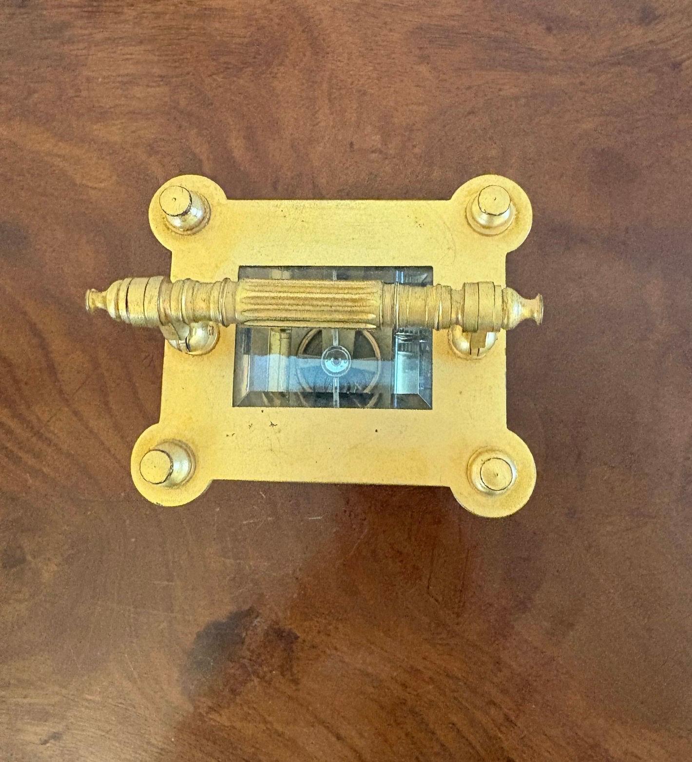 Outstanding quality antique Victorian gilded French carriage clock having an outstanding quality ornate gilded case with reeded columns, swing carrying handle to the top, circular porcelain dial with Roman numerals, original hands, 8 day French