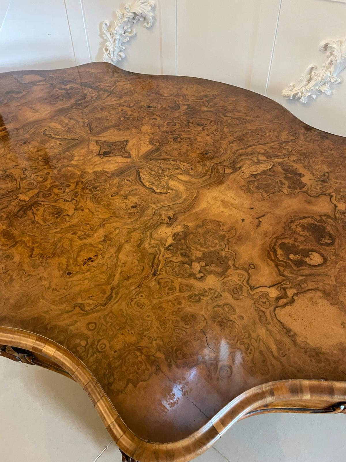 Outstanding quality antique Victorian large carved burr walnut centre table having an outstanding quality large serpentine shaped burr walnut top with a thumb moulded edge, magnificent quality carved serpentine shaped frieze supported by a turned