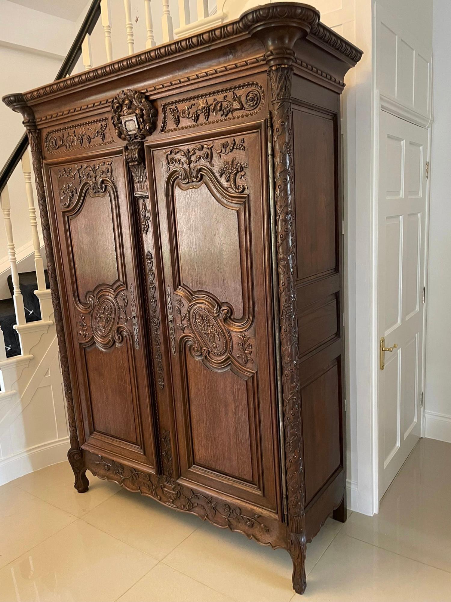 Outstanding quality antique Victorian large carved oak wardrobe having an outstanding quality carved cornice above a beautifully carved frieze with carved grapes, swag, flowers and leaves supported by a carved centre section flanked by a pair of