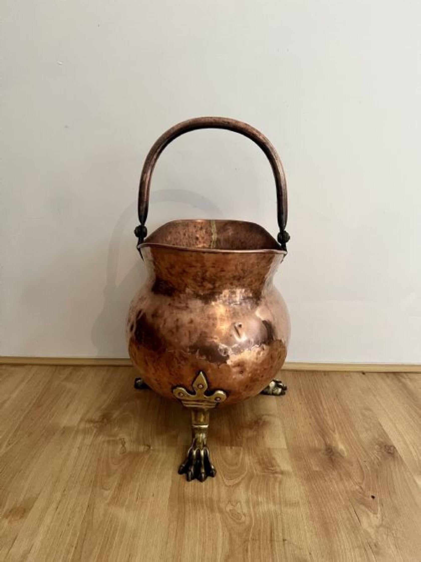 Outstanding quality antique Victorian large copper coal scuttle having a copper swing carrying handle above a shaped copper coal scuttle standing on large brass claw feet.