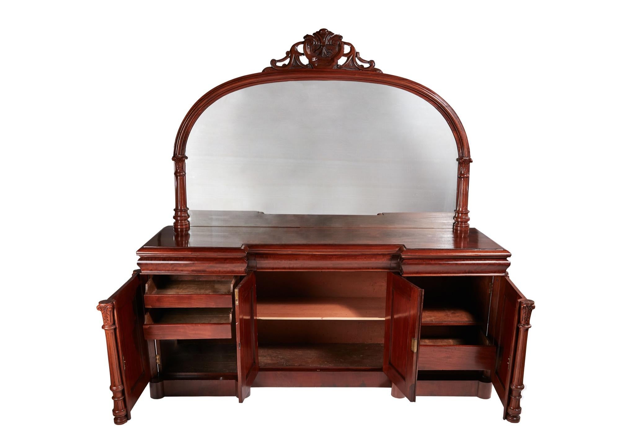 Outstanding quality antique Victorian mahogany mirrored sideboard having an invert breakfront top and three attractive shaped frieze drawers. It boasts a large carved mirror back. The four mahogany panelled doors are particularly admirable as are