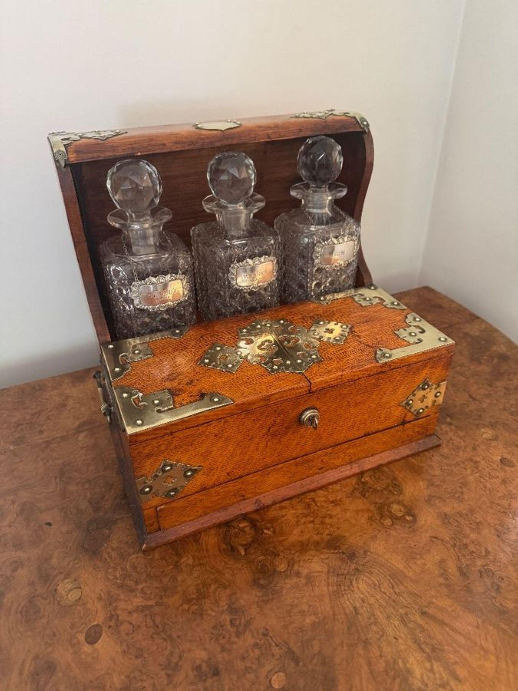 Outstanding quality antique Victorian oak tantalus and games box, having a quality oak tantalus with quality brass mounts and carrying handles to the sides, having a compartment with three square cut glass decanters with solid silver decanter tags