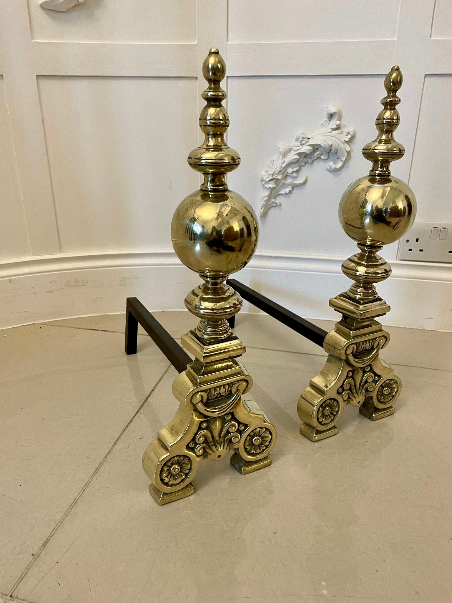 Outstanding quality antique Victorian pair of ornate brass fire dogs having turned brass tops, rounded balls to the columns standing on shaped ornate scroll feet united on an iron back stand 

Magnificent examples of desirable proportions and