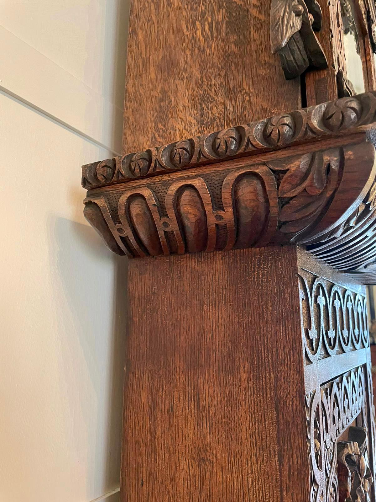 Outstanding quality carved oak brass face Grandfather clock with the hood having a shaped carved cornice, glass and oak door carved with sunflowers flanked by carved supports with carved leafs, fantastic carved long door to the case with a carved