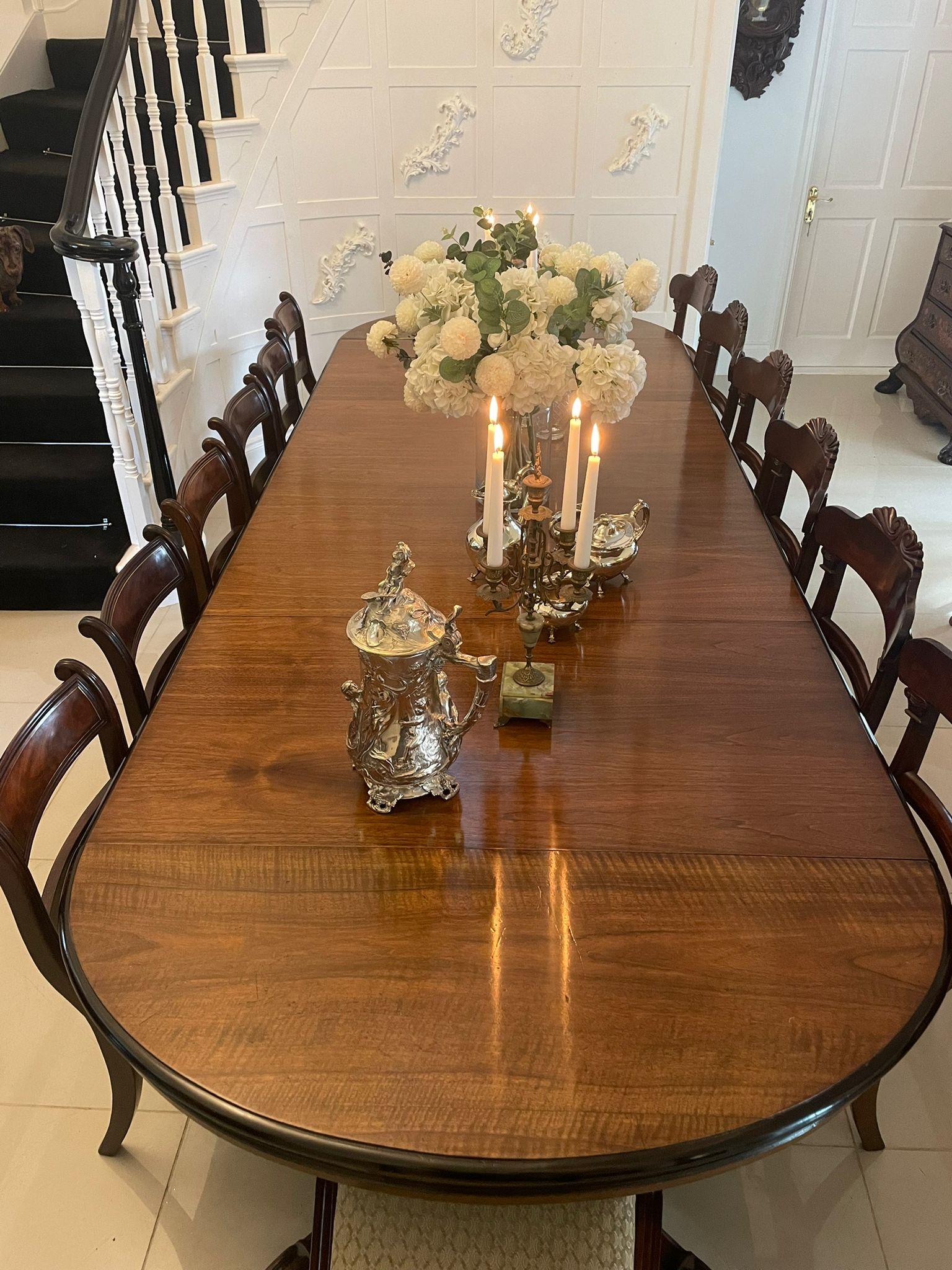 Outstanding quality large antique Victorian figured walnut extending dining table having an outstanding quality oval figured walnut top with an ebonised moulded edge with four original extra leaves, carved walnut frieze, pull out mechanism supported