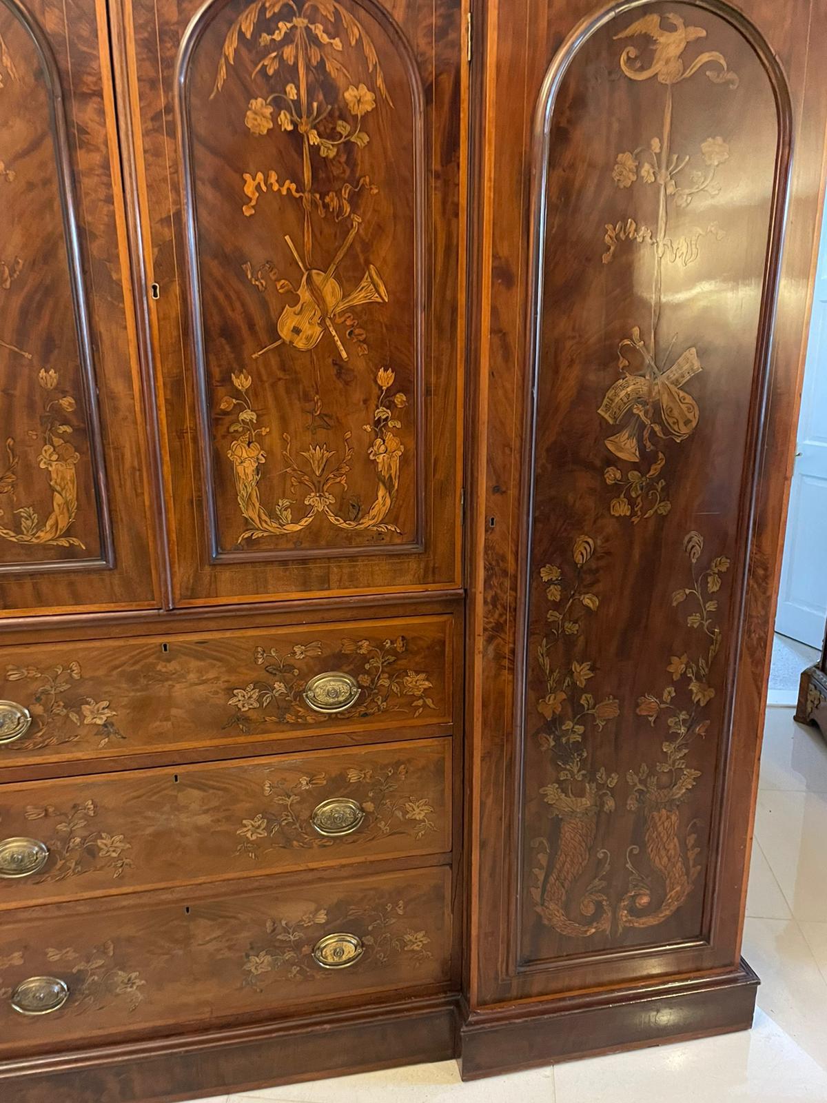 Outstanding quality large antique Victorian inlaid mahogany wardrobe having a magnificent quality inlaid satinwood and mahogany shaped cornice above a pair of moulded panelled doors with exquisite inlaid satinwood musical instruments, leaves,