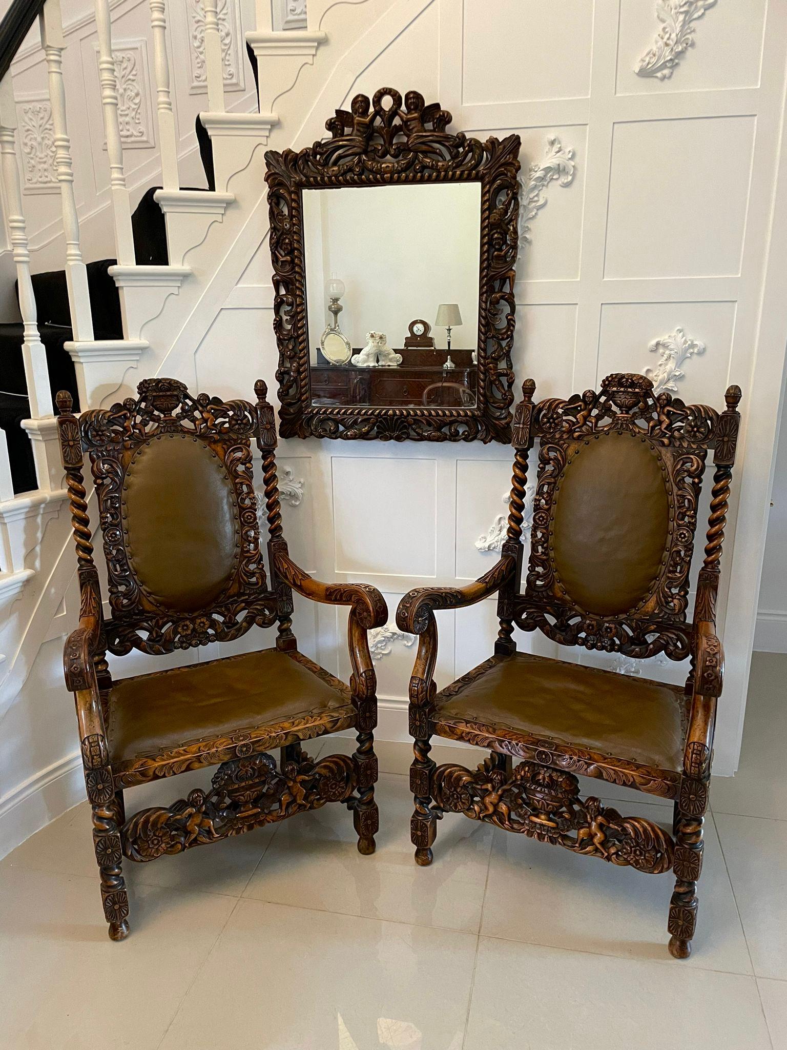 Outstanding quality large pair of antique Victorian carved walnut and leather armchairs having an outstanding quality carved back with a vase of flowers flanked by two cherubs scrolls and foliage, barley twist supports, shaped carved open arms with