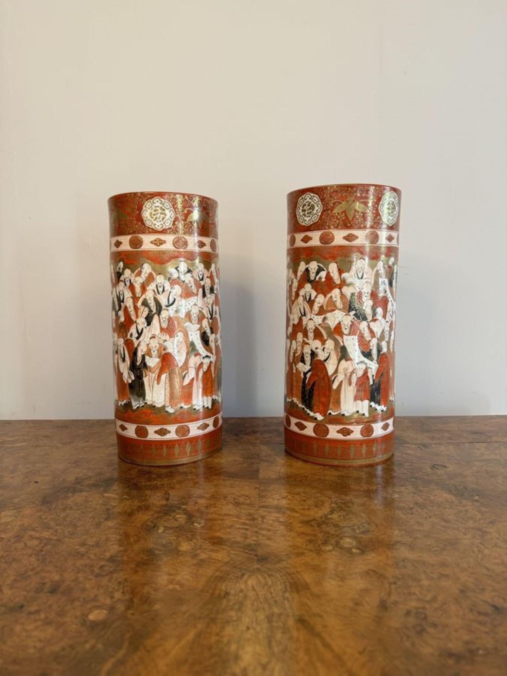 Outstanding quality pair of 19th century Japanese Kutani cylindrical vases, having a quality pair of antique Japanese Kutani porcelain cylindrical vases with quality hand painted Japanese figural scenes in period clothing in stunning red, orange,