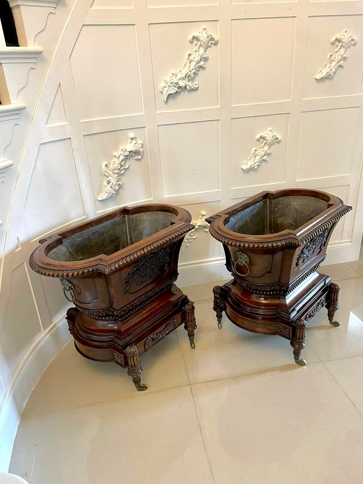 Outstanding quality pair of antique Victorian freestanding carved mahogany wine coolers
having opened tops with a carved moulded edge, the insides boating the original lead lining. Incredible quality carved mahogany panels with baskets of flowers,