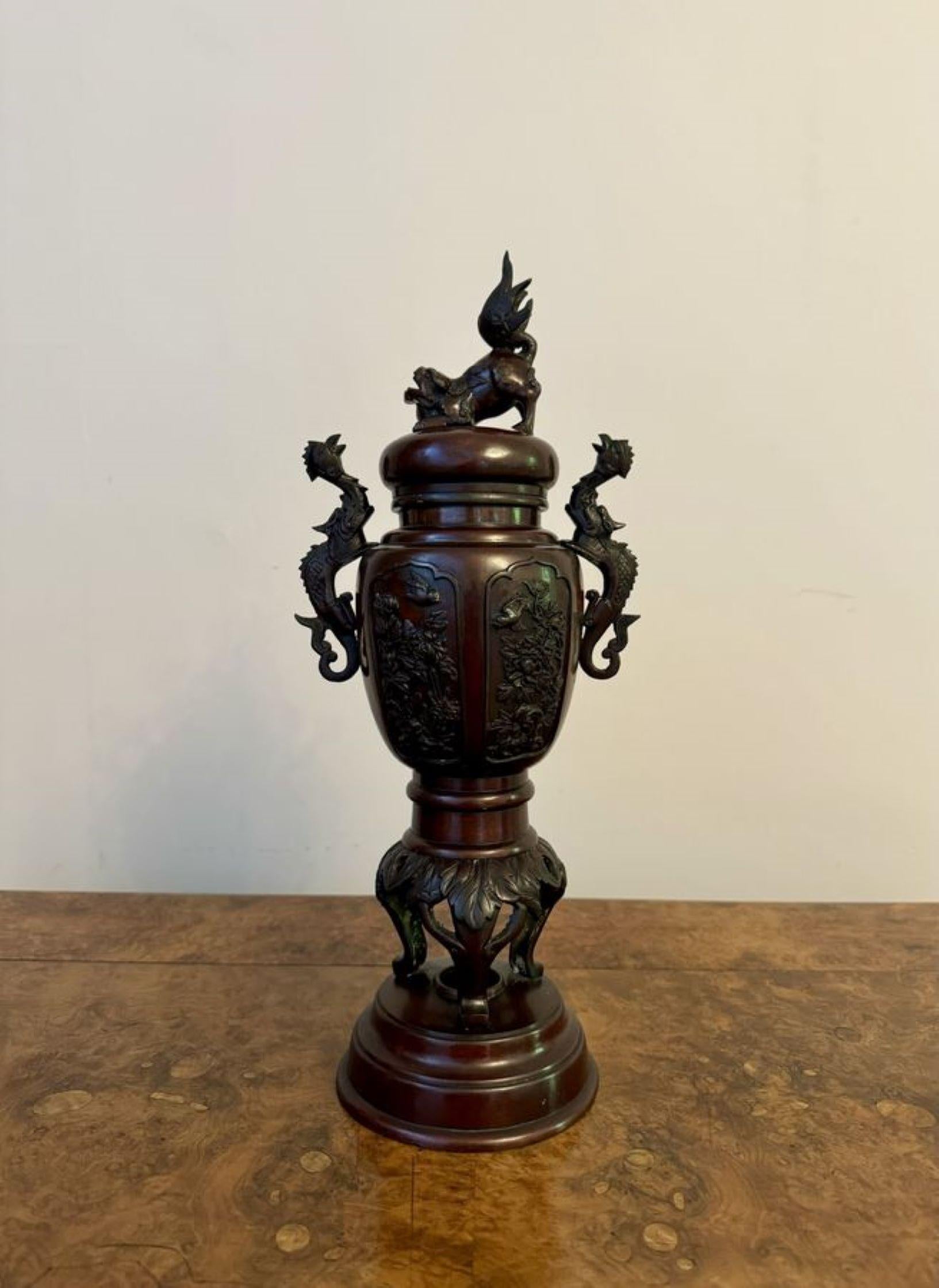 Outstanding quality pair of antique Japanese bronze lidded vases, having a quality pair of Japanese baluster bronze vases decorated with foliage and birds, flanked by twin dragon handles, the lids surmounted by Dogs of Fo, raised on circular shaped