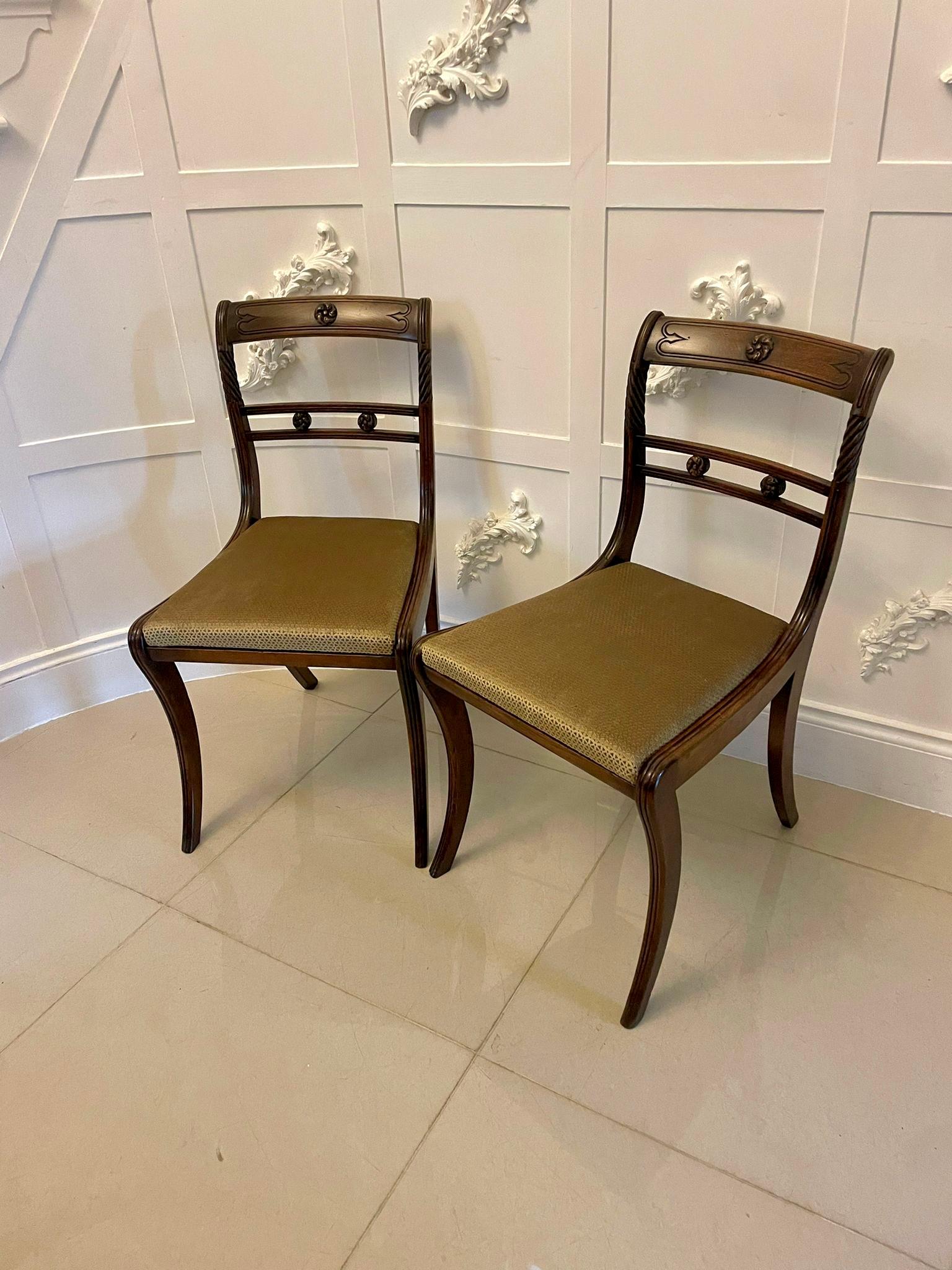 Outstanding quality pair of antique regency mahogany side chairs having exceptional quality carved top rails and centre splat, rope twist and reeded supports, newly reupholstered seats in a quality gold tone  fabric standing on reeded sabre legs