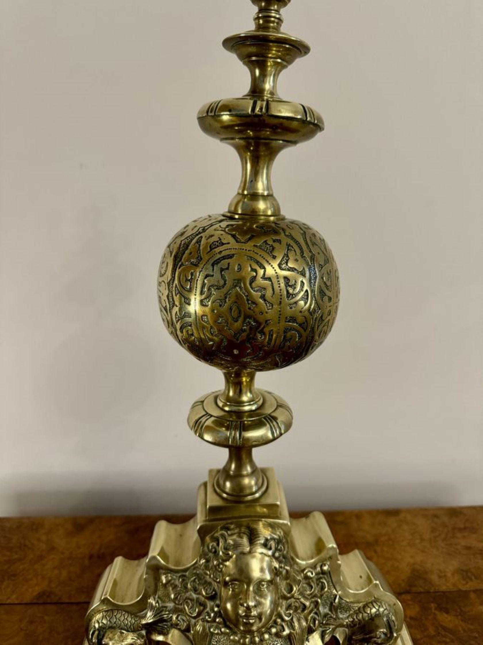 Paire exceptionnelle de chiens de garde en laiton ornés de l'époque victorienne. Paire de chiens de garde en laiton ornés de masques sur les bases, surmontant des pieds de forme carrée. 

D. 1880