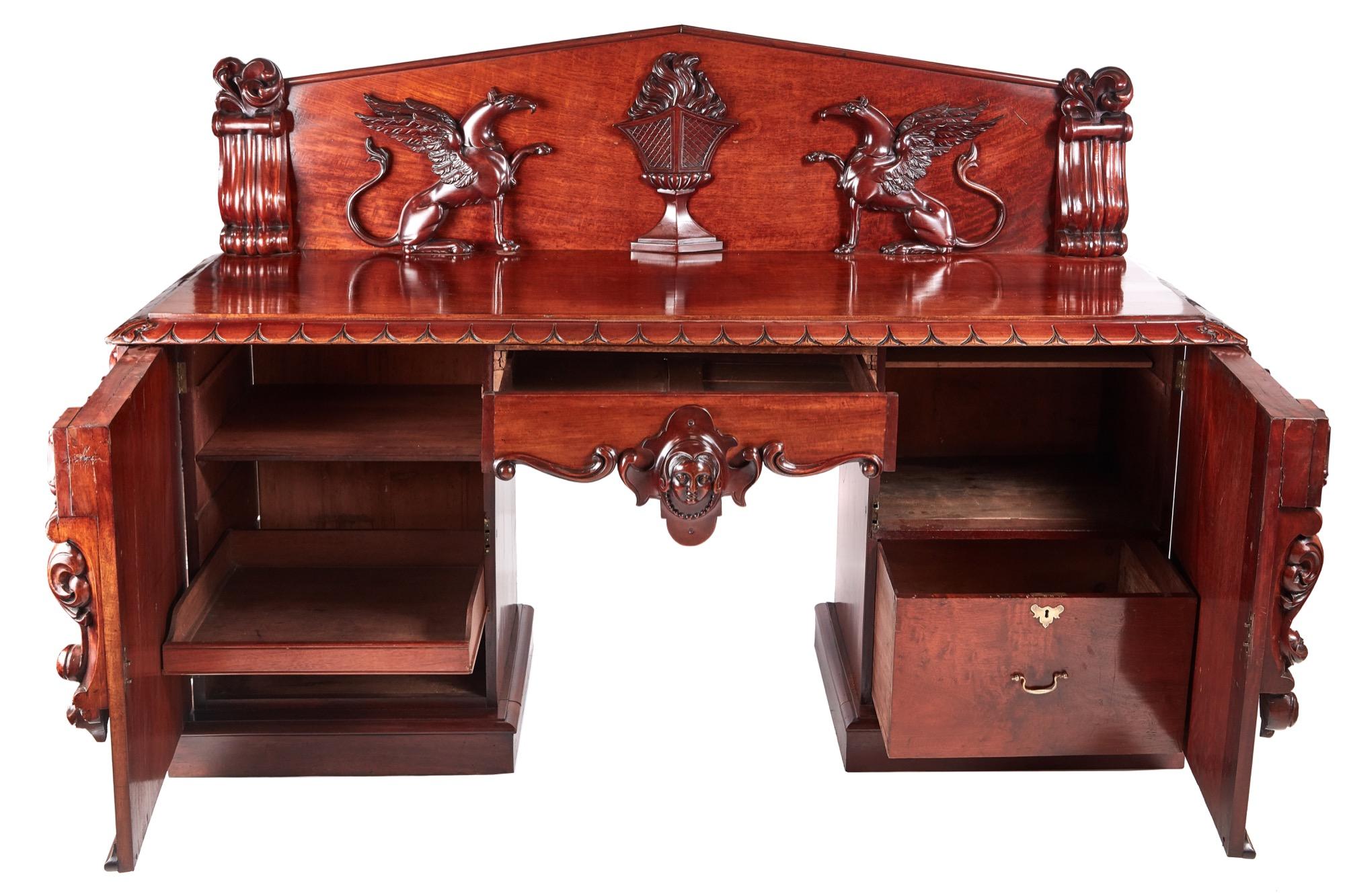 This is truly an outstanding example of a William IV carved mahogany antique sideboard. The back is faced with a pair of high-relief exceptionally detailed carved griffons flanking a central flaming urn. The base having an outstanding mahogany top