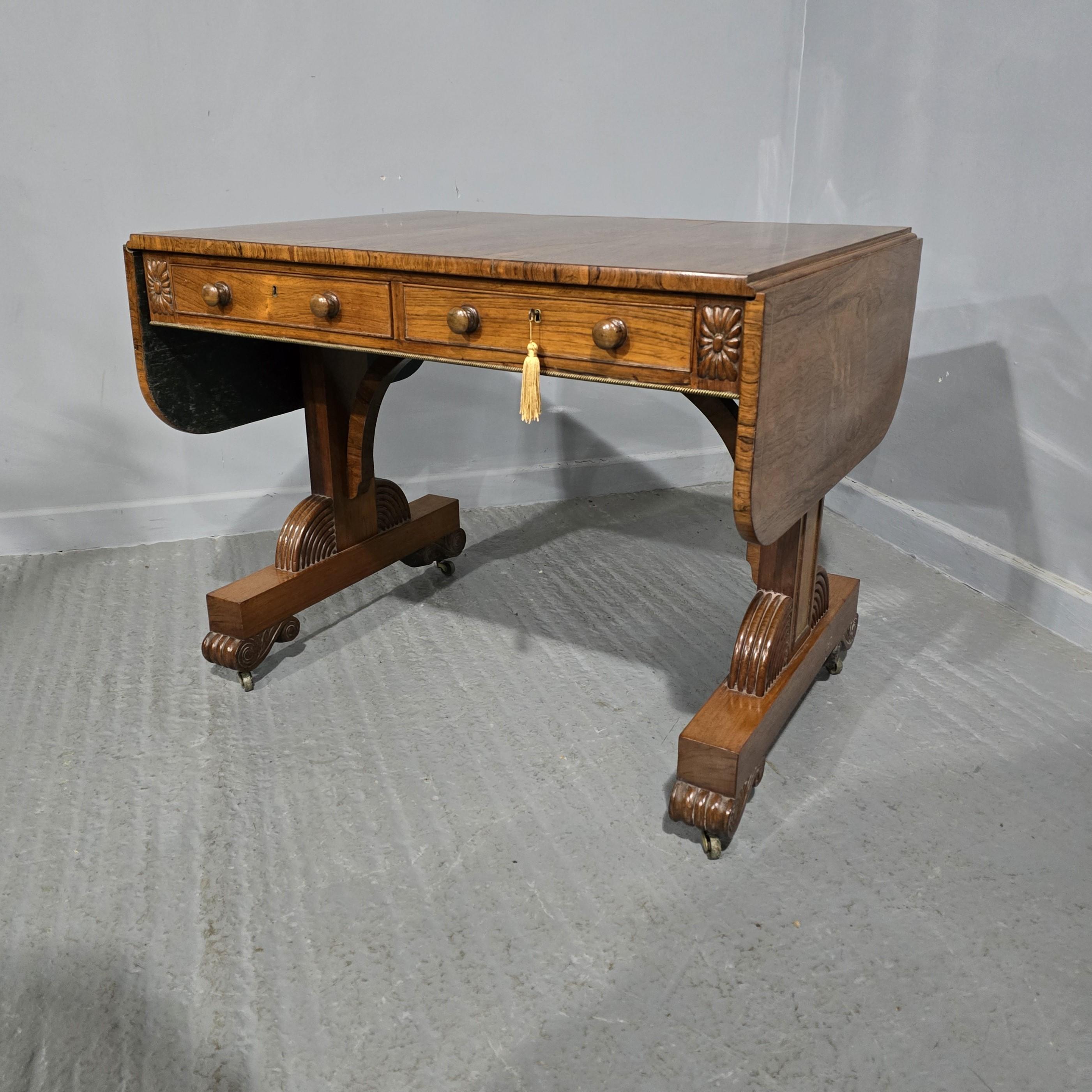Exceptional brass inlaid, Regency sofa table in rosewood, having stunning figured and brass inlaid drop leaf top above 2 cockbeaded drawers and 2 dummy drawers to opposite side fitted with turned knobs, all raised on elegant supports with reeded