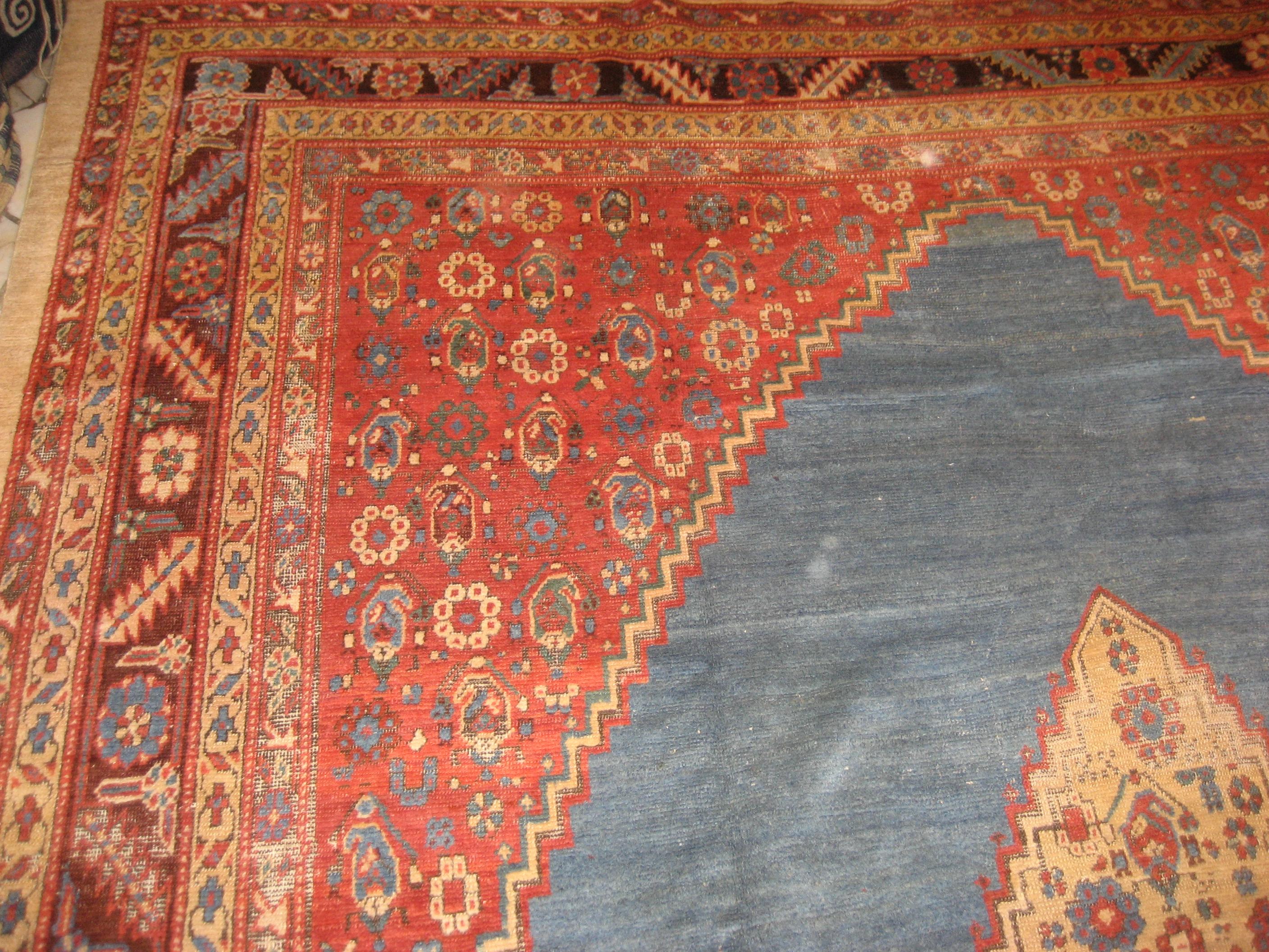 The subtly changing sky-blue background of this fascinating carpet, obtained by means of a number of colour gradations, creates the impression of a sea on which floats a sun-like lozenge, spangled by polychrome rosettes. The refined primitivism of