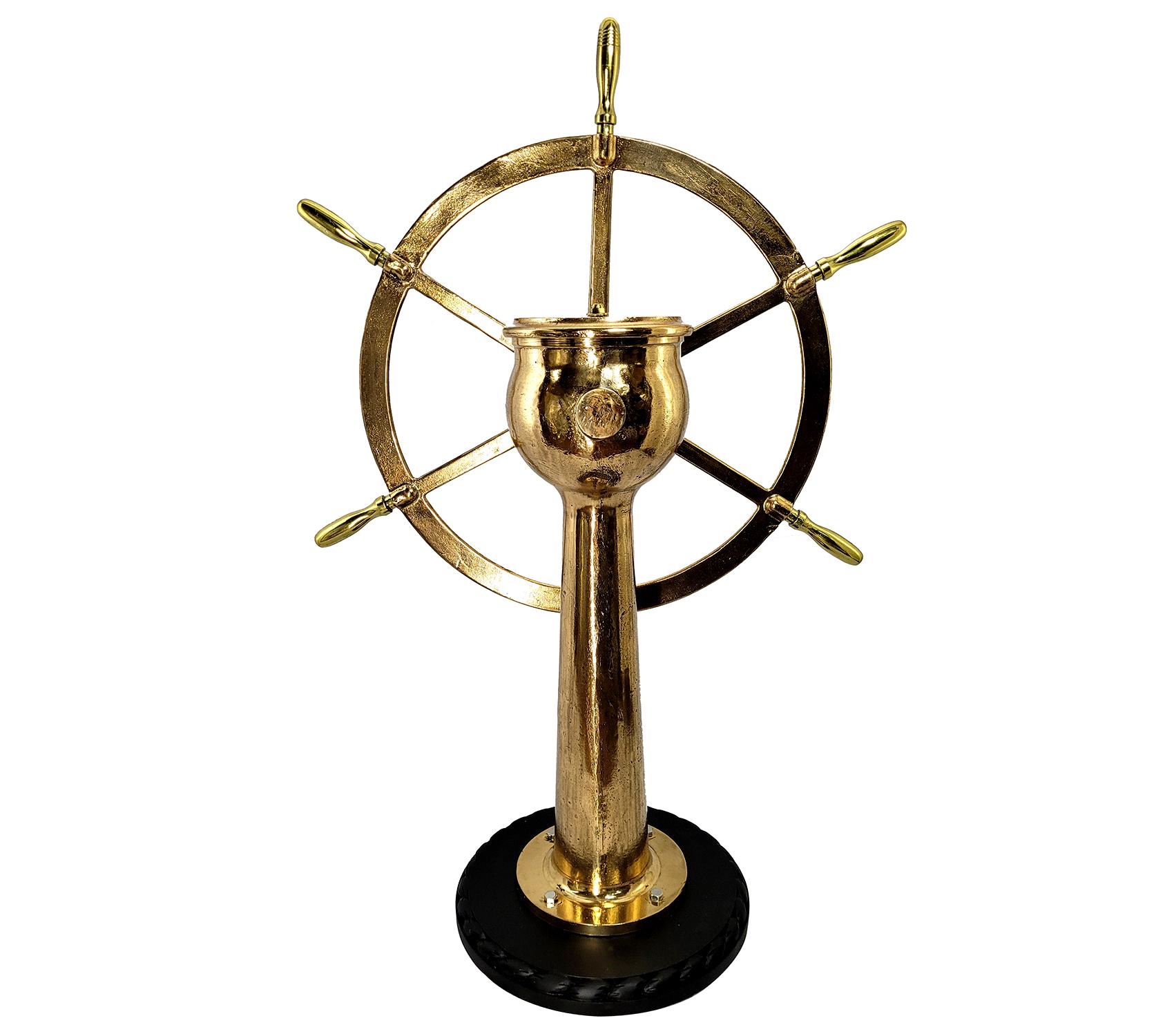 Very impressive six spoke ships wheel mounted to a geared pedestal. The pedestal head is engraved Dake Engine Company, Grand Haven Michigan, serial number 6595 with rudder indicator arrow. Entire unit has been meticulously polished and lacquered.