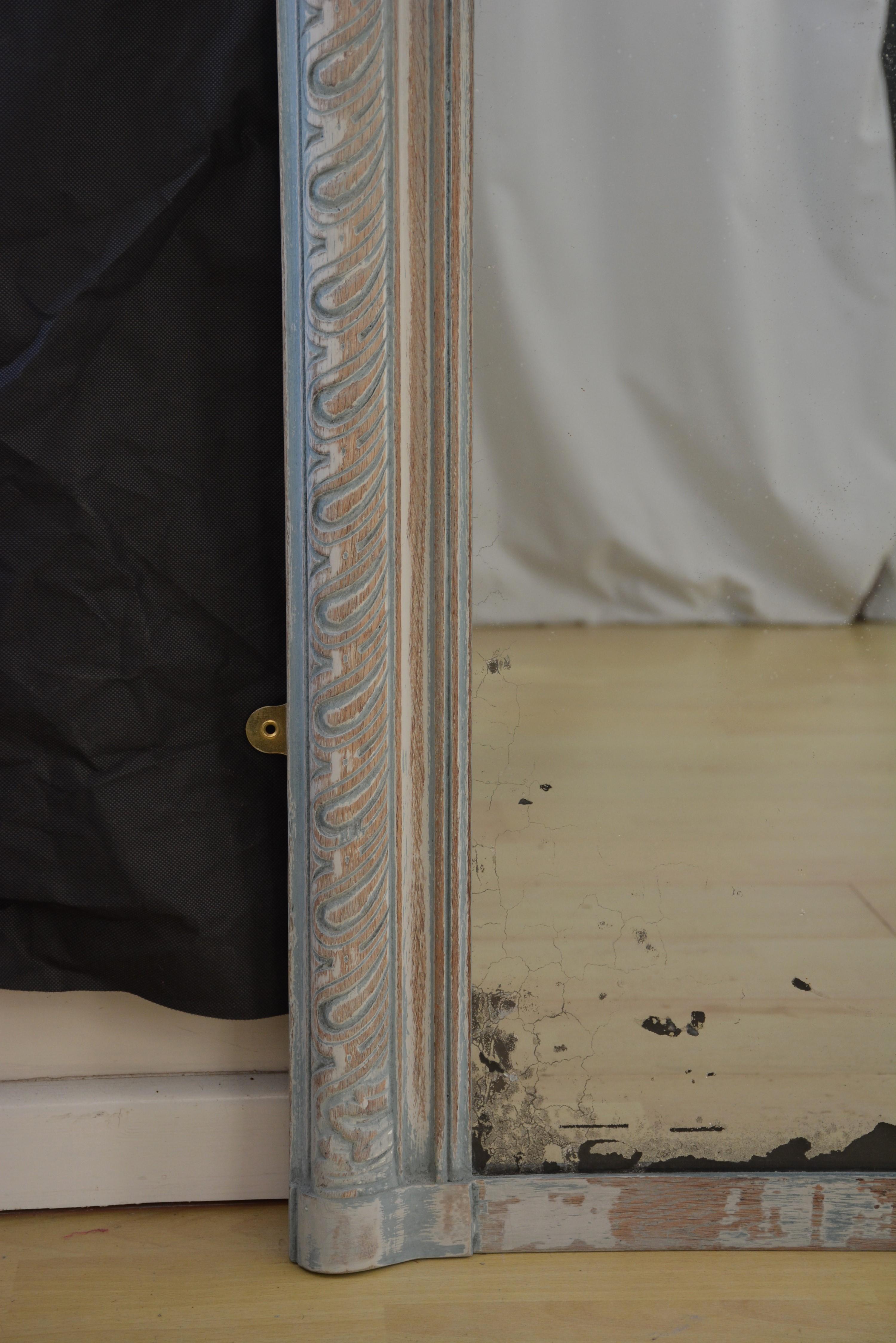 P0189  Grand miroir d'appui / miroir mural ancien en chêne, avec verre d'origine présentant quelques imperfections et argentures, dans un cadre mouluré et finement sculpté, représentant des feuilles d'acanthe profondément lobées. Ce motif trouve son