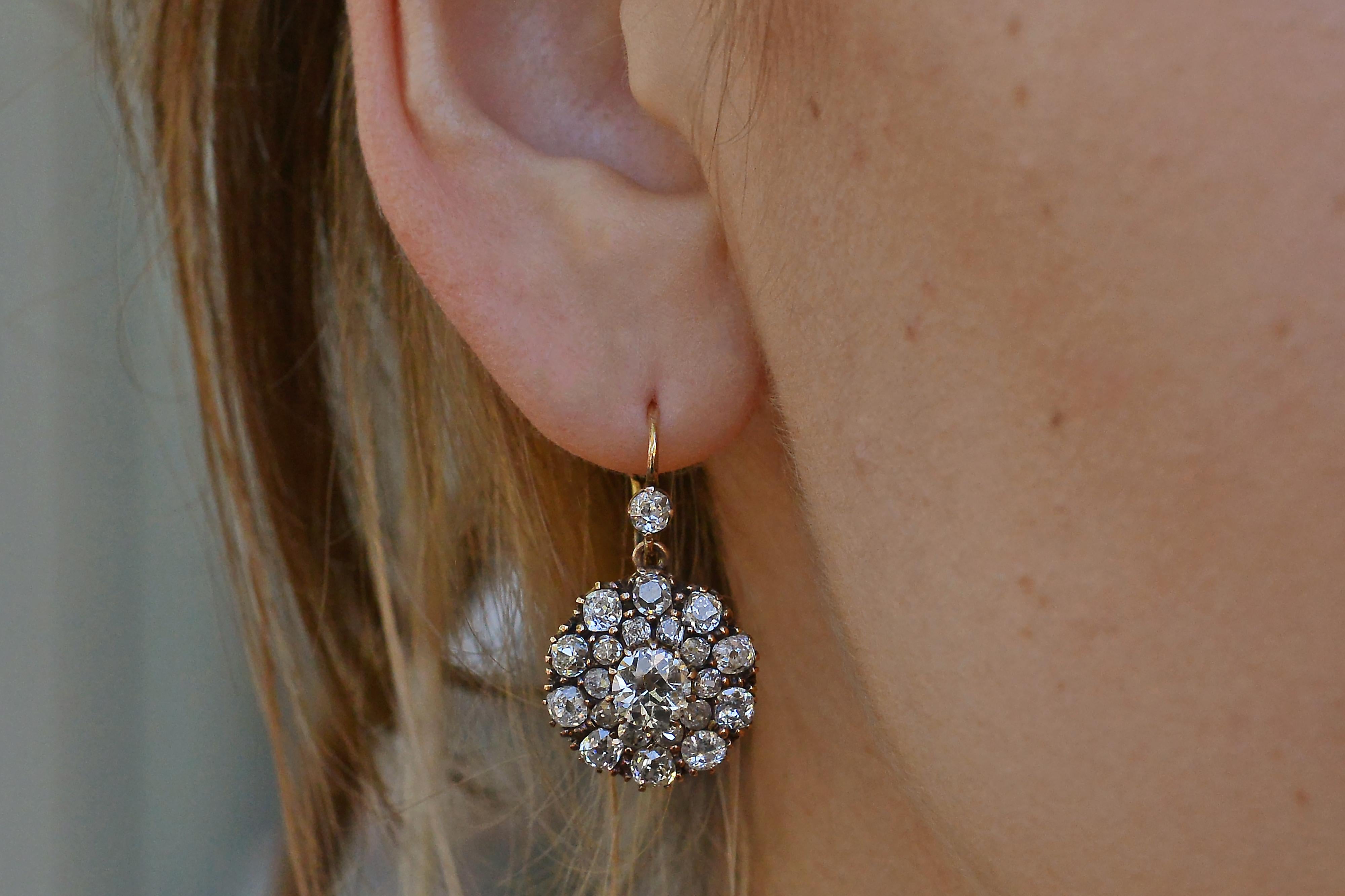 An antique bombshell pair of earrings bursting with incredible glimmer and glamour. This authentic late 1800s Victorian set is loaded with classically elegant old mine cut diamonds that allow the light to dance within them as they dangle on your