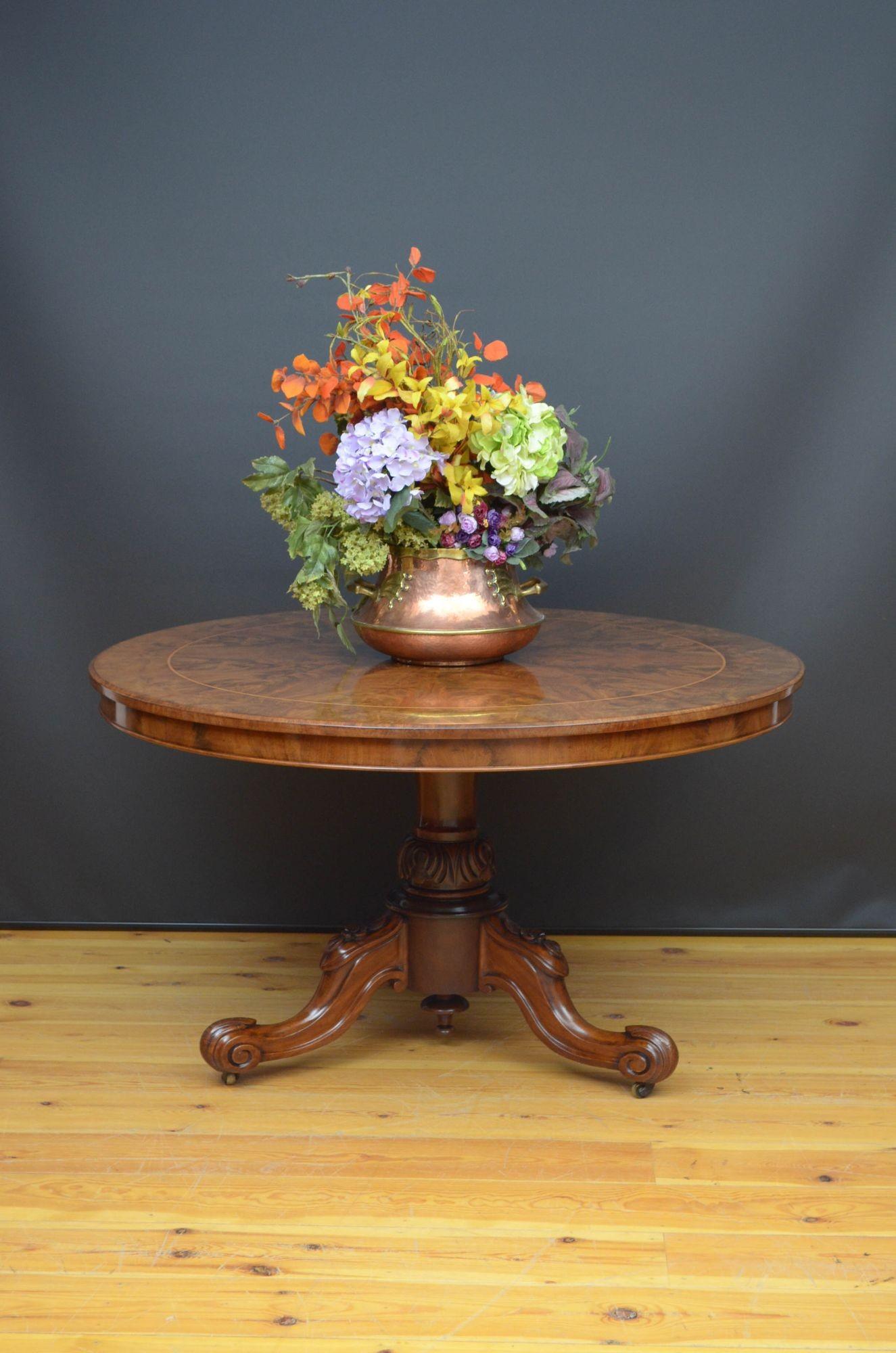 Sn5378 Outstanding Victorian tilt top table, having segmented flamed mahogany veneered top with decorative string inlay, raised on finely carved column terminating in three carved cabriole legs and castors. This antique table is in home ready