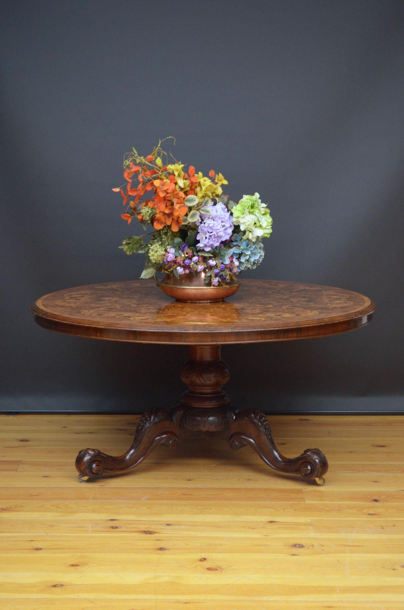 Sn5154 A magnificent Victorian tilt top table, having finely inlaid top with satinwood scrolls, floral motifs throughout and satinwood banded edge raised on substantial, lotus carved column terminating in three cabriole legs with carved vine
