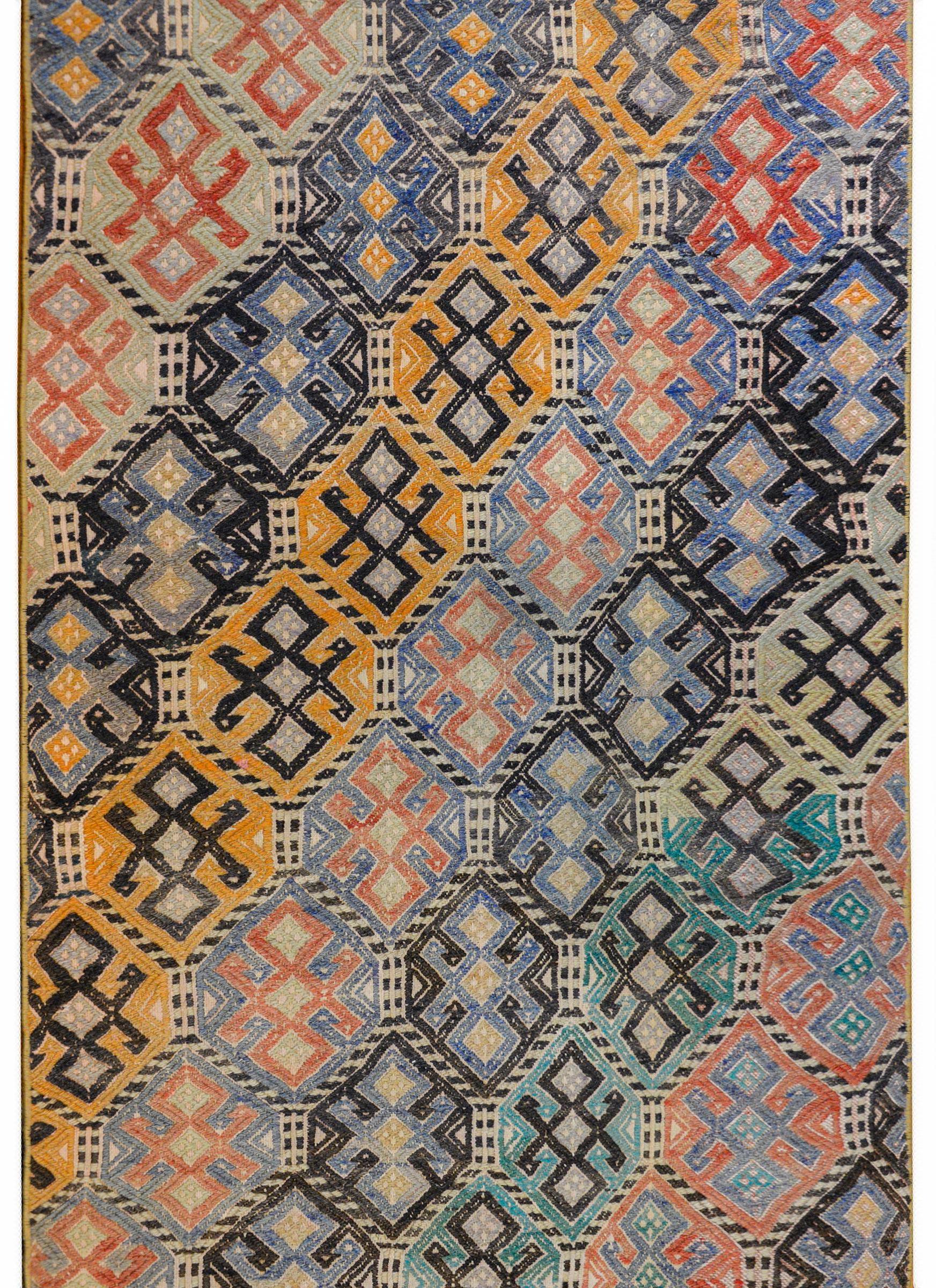 An outstanding vintage Turkish Cicim runner with an all-over pattern of geometric shapes woven in myriad colors like crimson, mint green, lavender, and gold, and organized in a striped pattern that runs diagonally across the field.